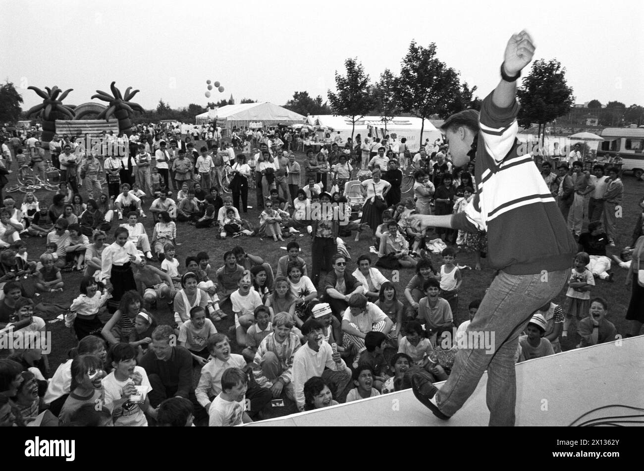 An entertainer amsuses a passel of children at the Danube Isle Festival in Vienna on May 24th 1990. Moderator: Robert Steiner. - 19900524 PD0008 - Rechteinfo: Rights Managed (RM) Stock Photo