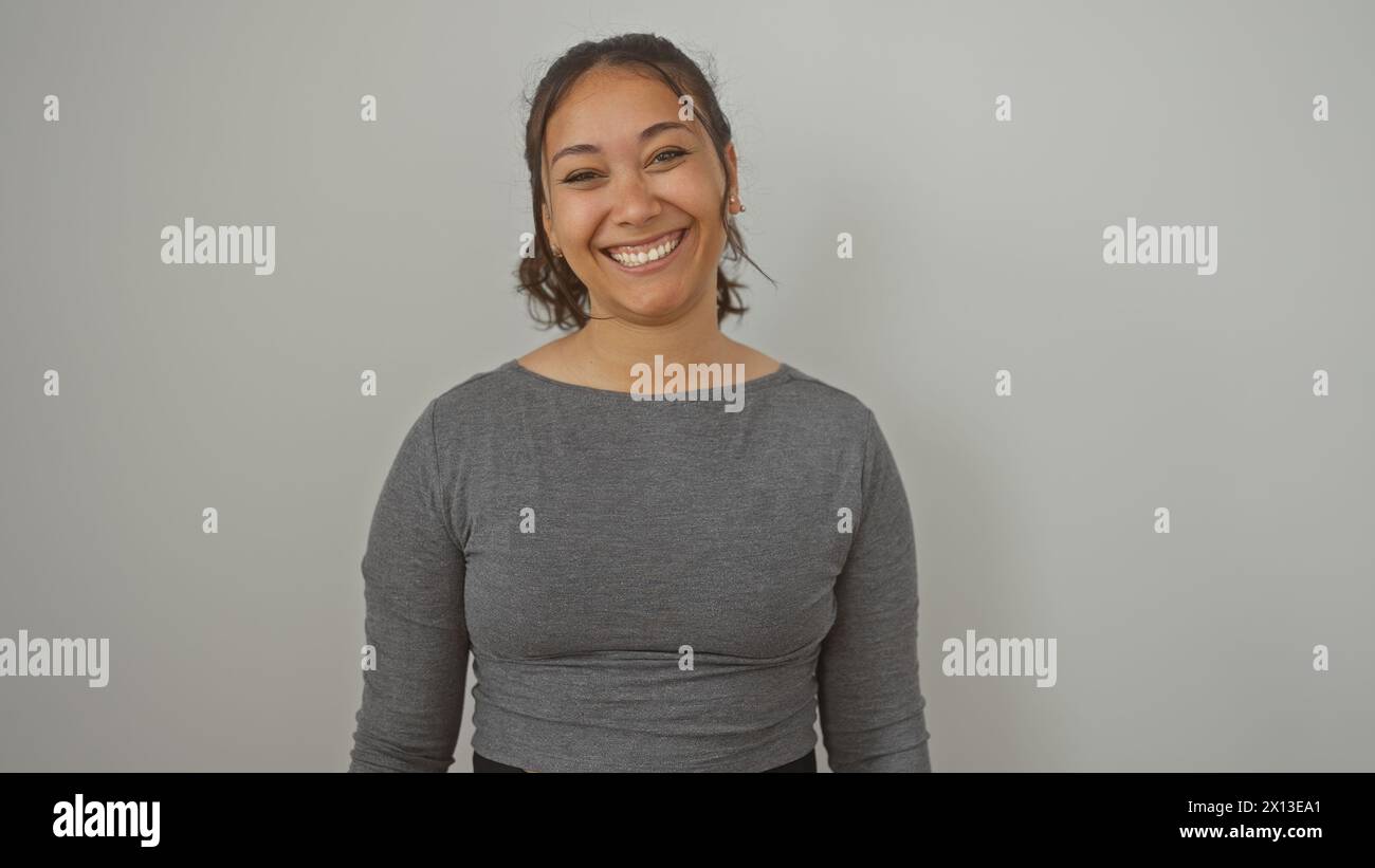 Hispanic Poses A smiling young adult hispanic woman poses in casual clothing against ...