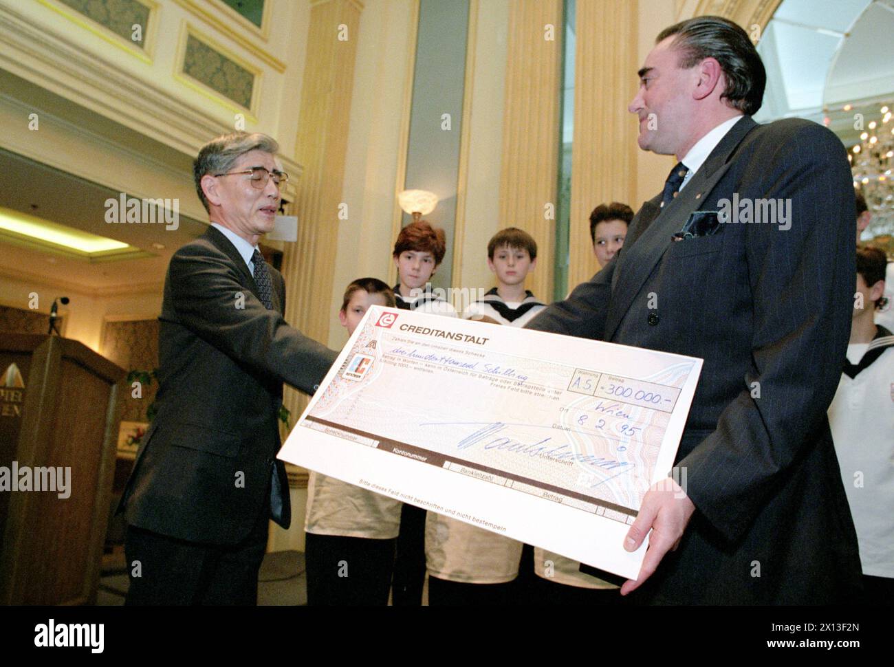 Vienna on February 8th 1995: Vienna Boys' Choir gave a concert in benefit of children in the earthquake threatened area of Kobe, Japan. In the picture: Tsuyoshi Kurokawa (l.), Japanese ambassador to Austria, receives a cheque of 300.000 Austrian Schillings from the Walter Tautschnig jun., director of the choir. - 19950208 PD0007 - Rechteinfo: Rights Managed (RM) Stock Photo