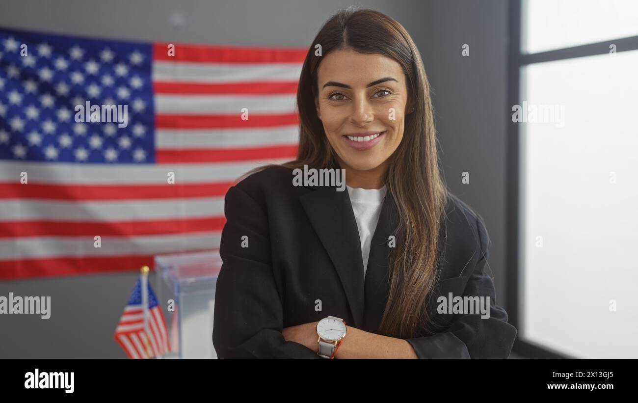 Confident hispanic woman in business attire with crossed arms in front of an american flag indoors Stock Photo