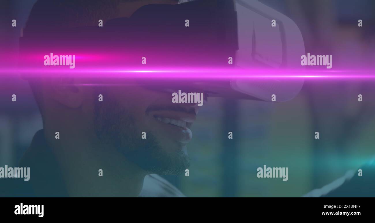 Image of blue and pink light trails moving over biracial man wearing vr ...