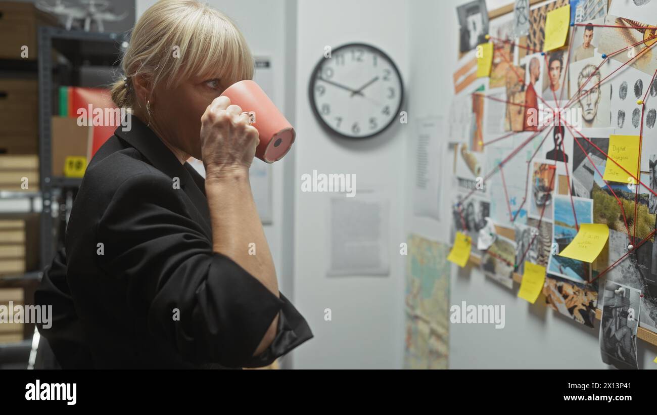 A blonde woman investigates crime at the police station, examining a board of clues while sipping coffee. Stock Photo