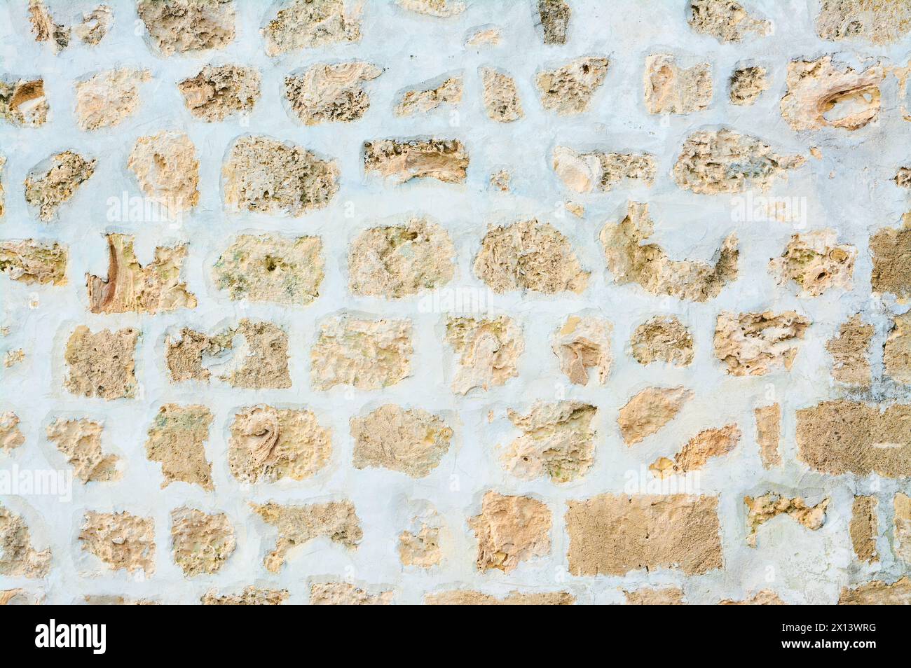 A limestone wall of flush-finished random rubble with mortar on the exterior of an historical building in Fremantle, Perth, Western Australia. Stock Photo