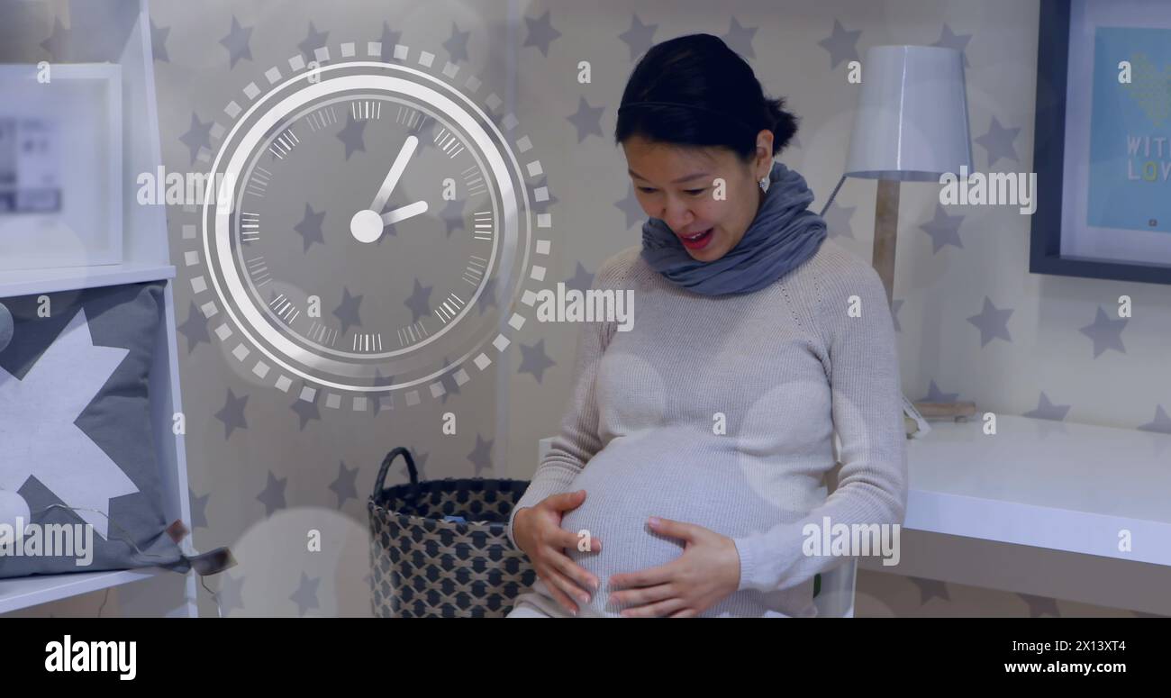 Fast moving clock and bokeh lights over happy a pregnant asian woman rubbing belly Stock Photo