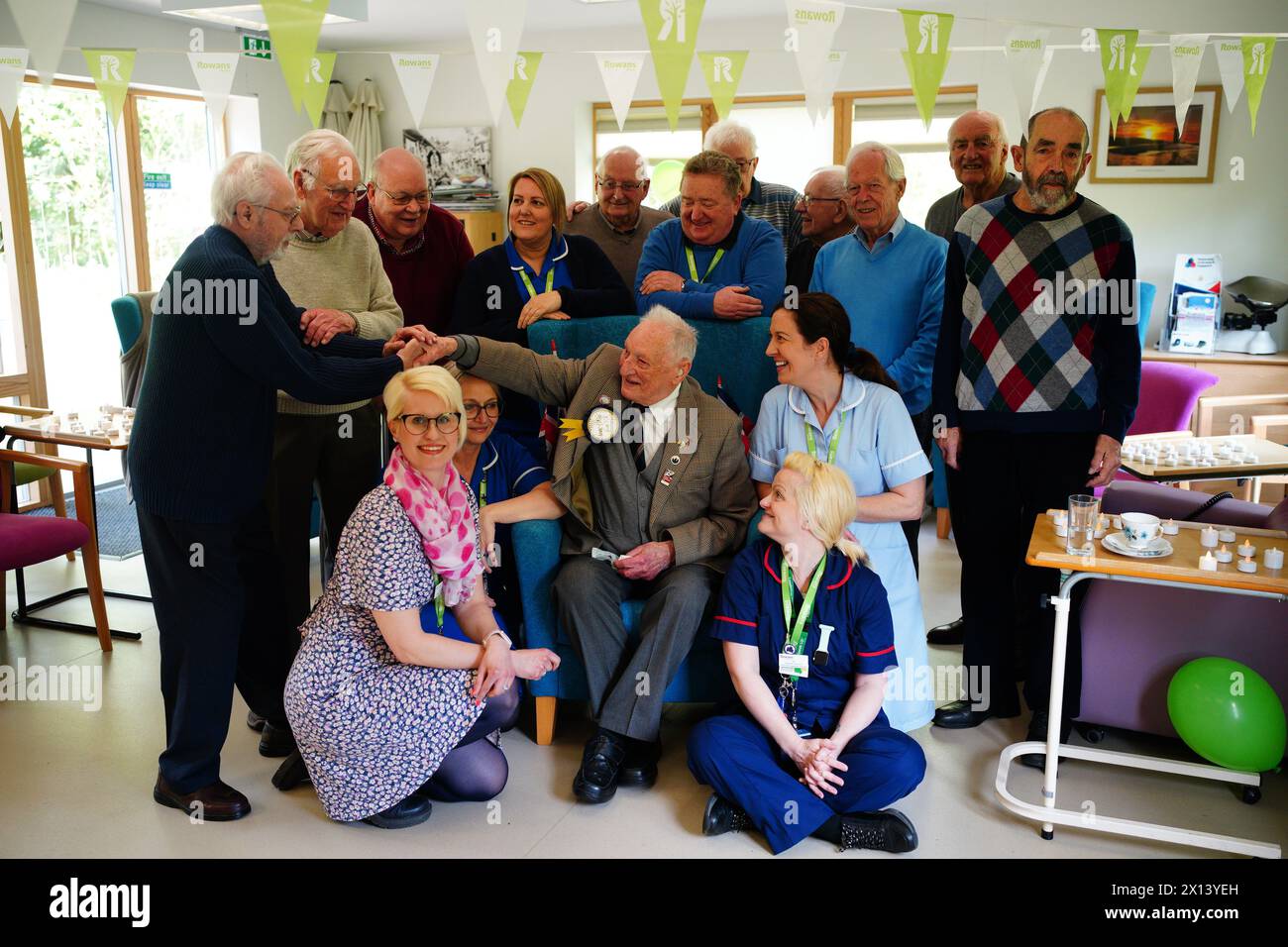 Former World War II squadron leader and Royal Air Force fighter pilot Derrick Grubb celebrates his 100th birthday, which fell last Friday, with his friends, and staff and volunteers during a party at Rowans Hospice Living Well Centre in Waterlooville, Hampshire. Picture date: Monday April 15, 2024. Stock Photo