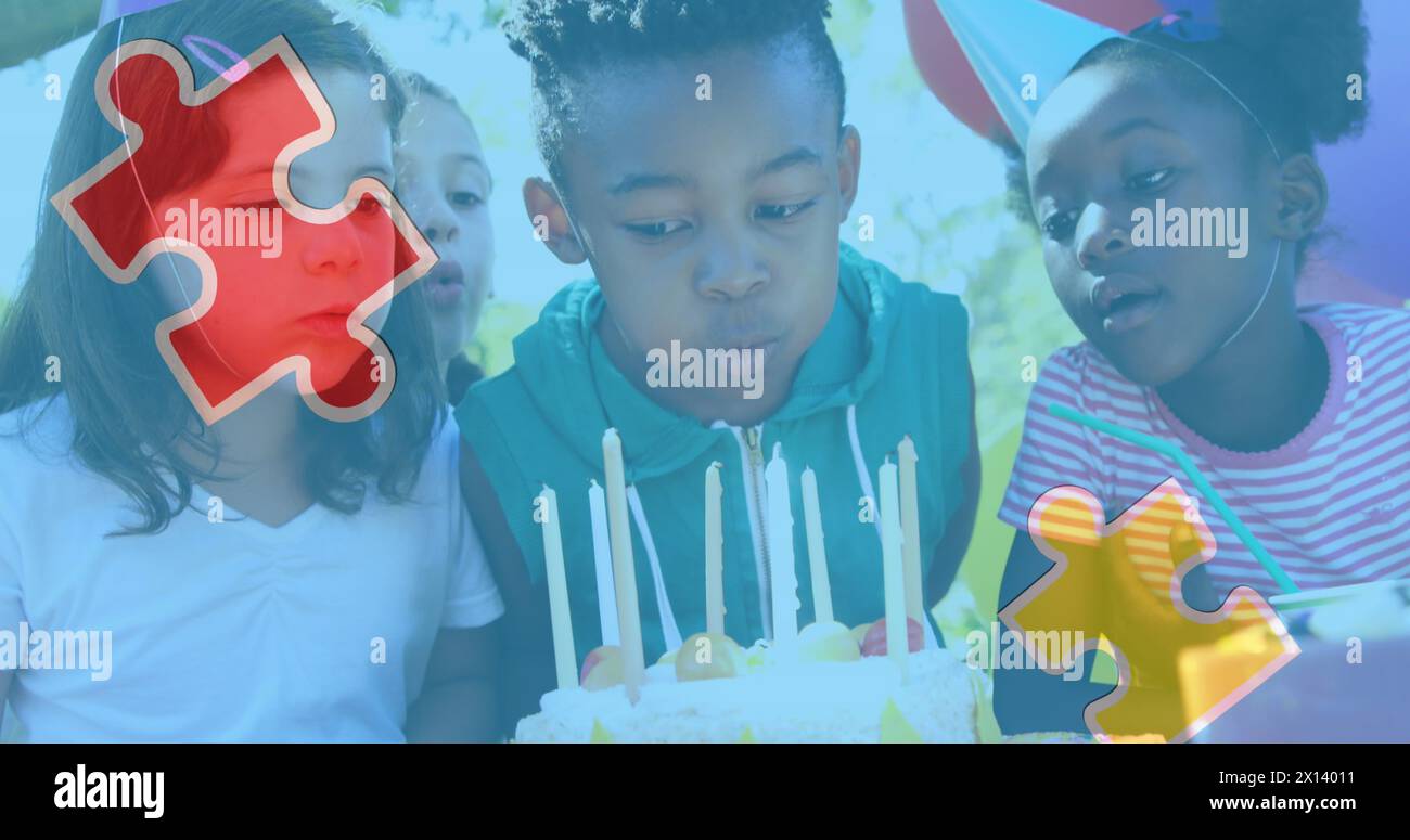 Image of colourful puzzle pieces over children with birthday cake at party Stock Photo