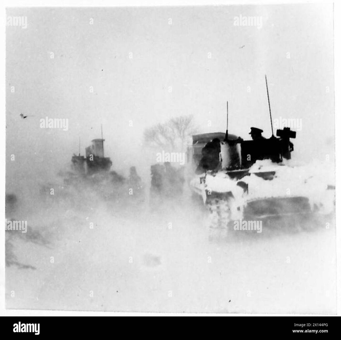 TANKS EXTRICATE MOTOR COACH FROM SNOWDRIFT - Tanka extricating the motor coach during a blizzard British Army Stock Photo