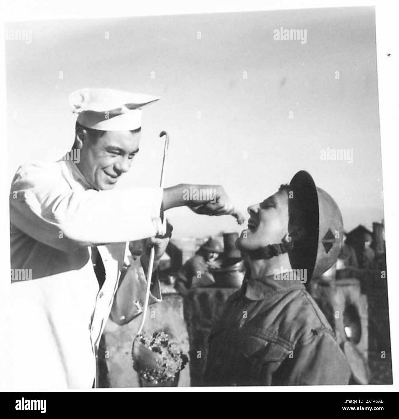 CHRISTMAS TIME IS PUDDING TIME - One of the troops receives a taster from an Army Cook while preparing the puddings British Army Stock Photo