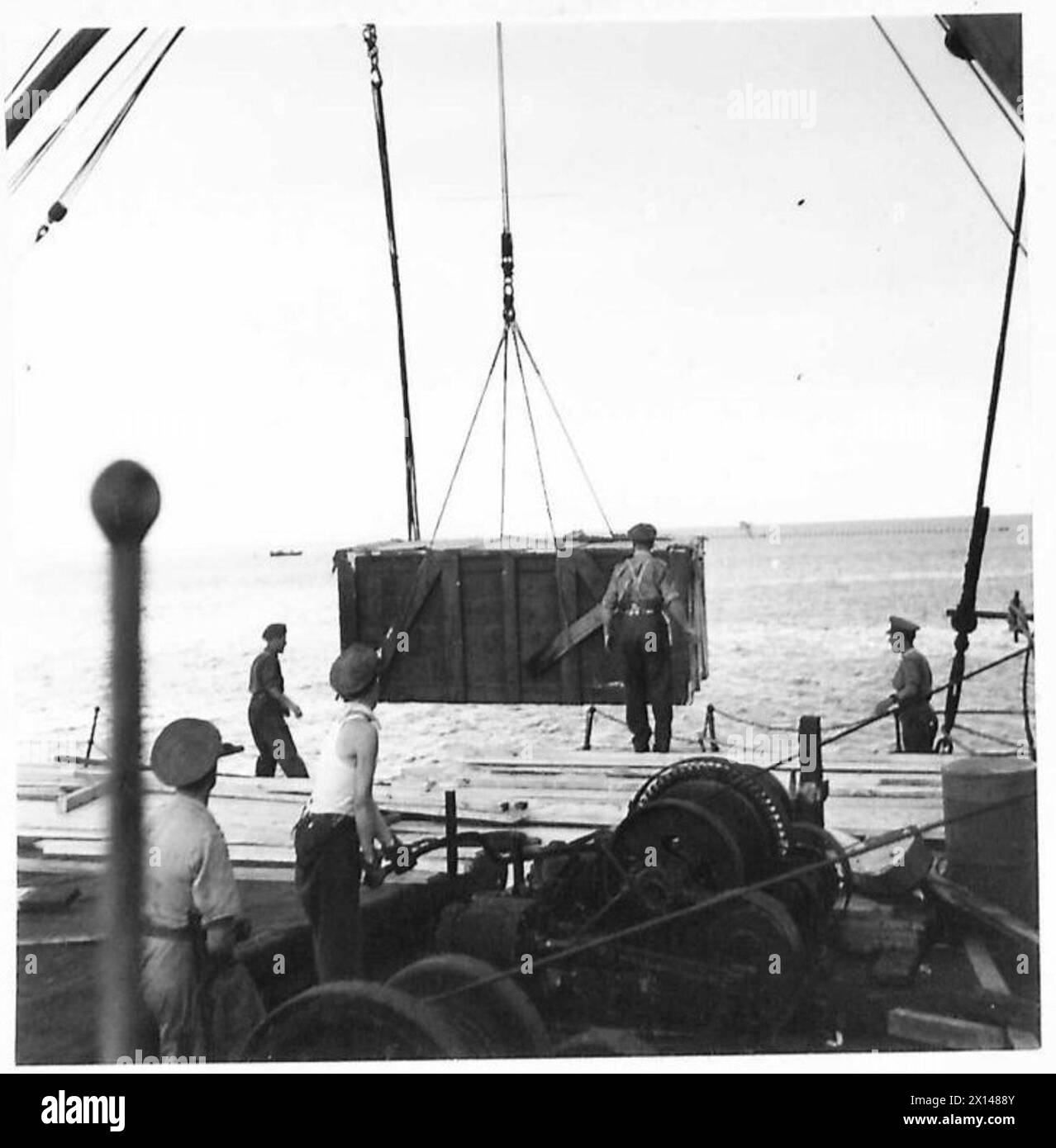 CANADIAN TRUCKS REACH MIDDLE EAST Crates being slung from a ship in