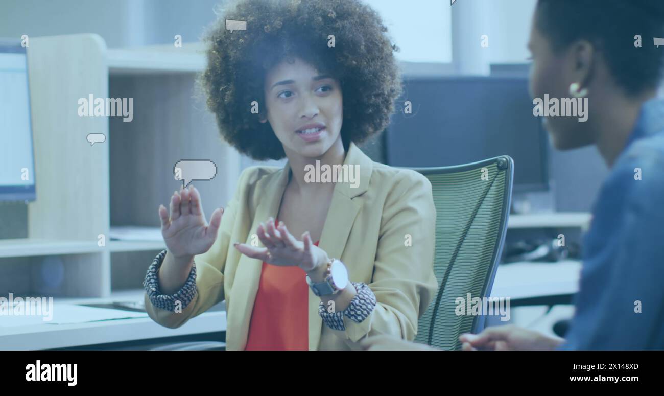 Image of speech bubbles over diverse business people discussing work Stock Photo