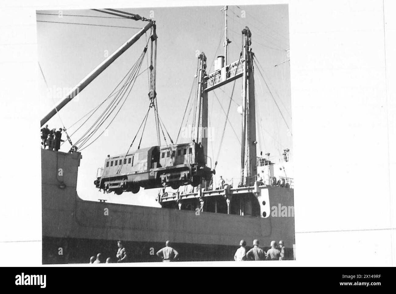 PHOTOGRAPHS OF PREFABRICATED PORT, ETC. - Diesel loco hoisted from ship , British Army, 21st Army Group Stock Photo
