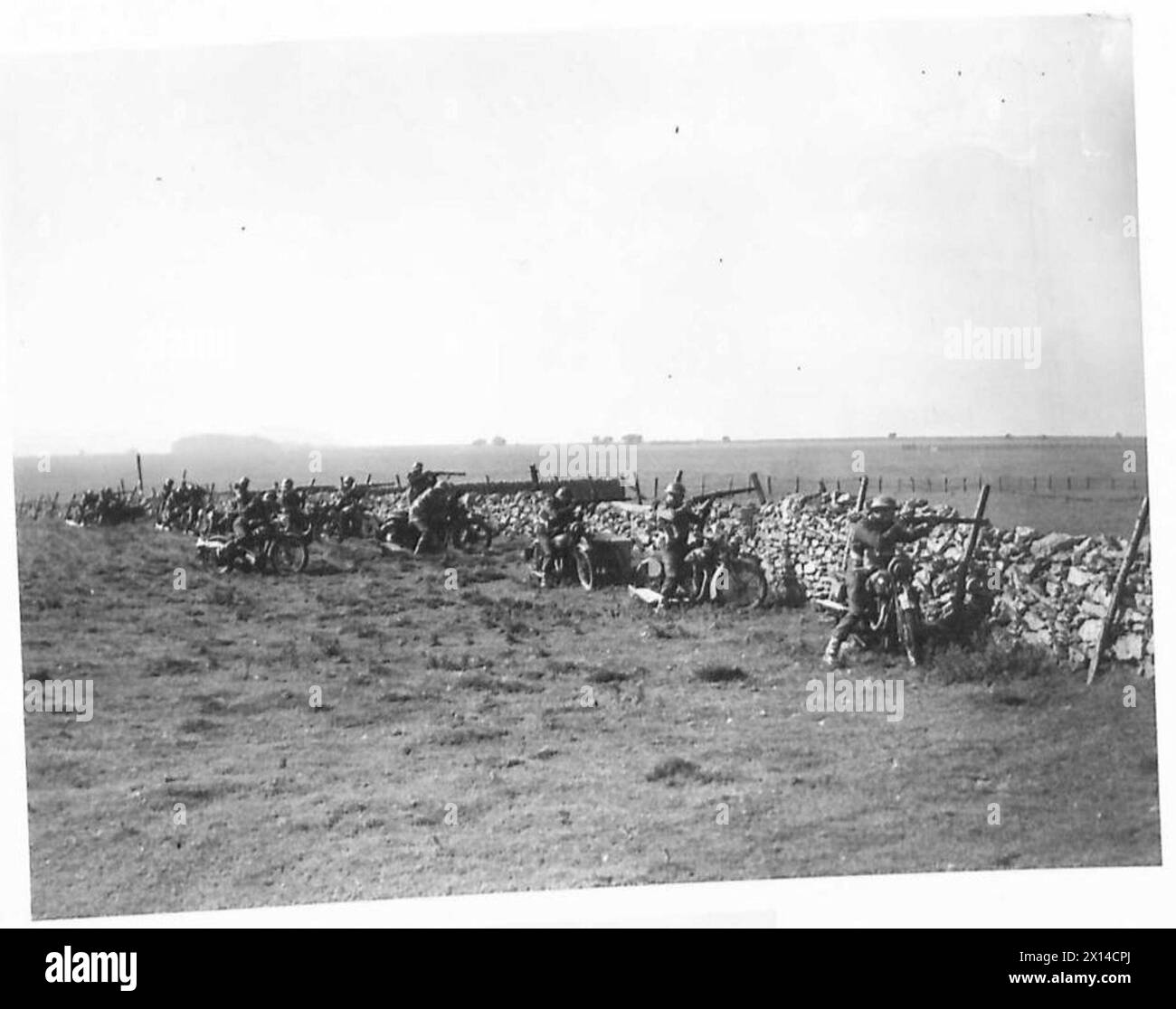 ROUNDING UP ENEMY PARACHUTISTS - The Motor Cyclist platoon take cover behind a dry brick wall and open fire British Army, 5th Battalion, Border Regiment, British Army, 125th Infantry Brigade, British Army, 42nd Division Stock Photo