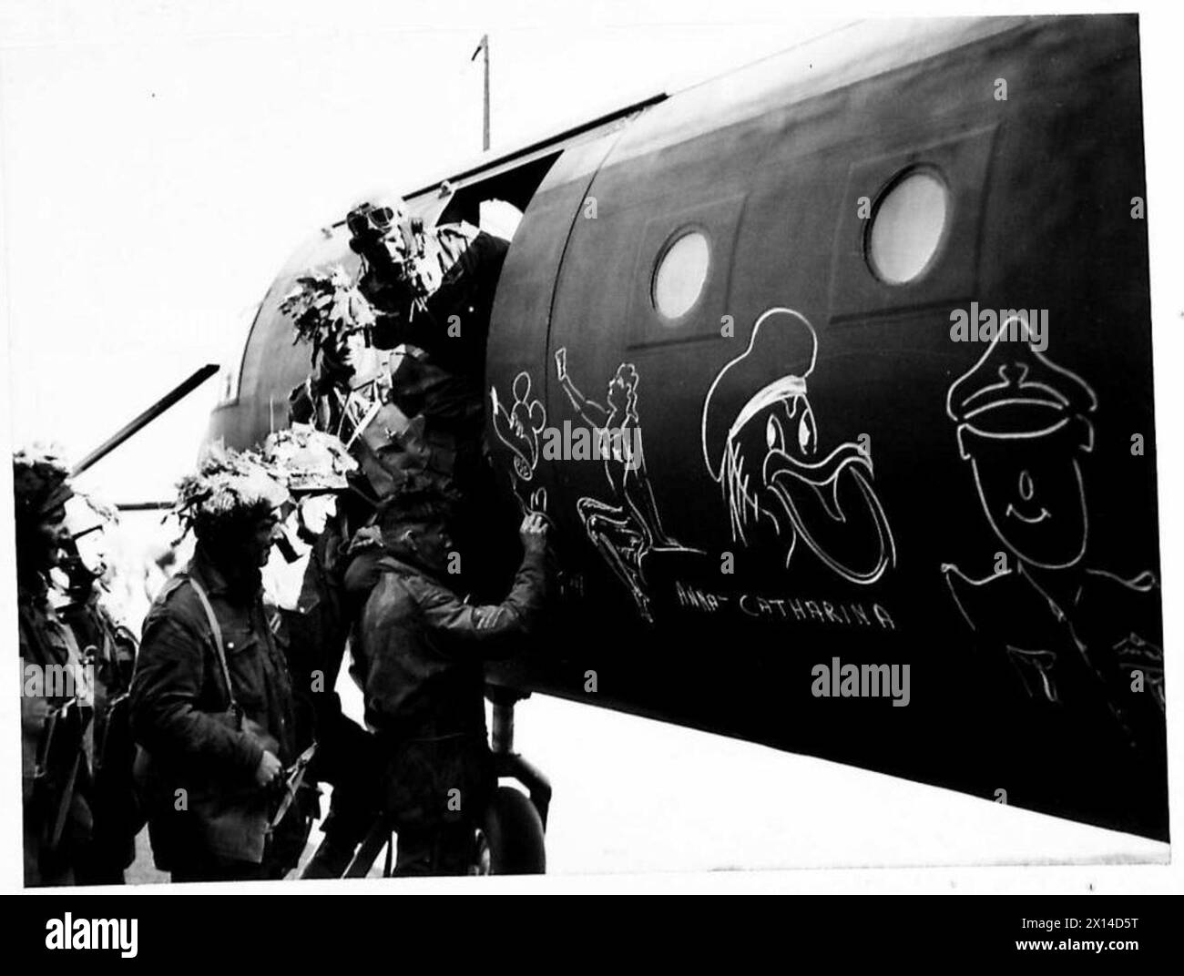 D-DAY - BRITISH FORCES DURING THE INVASION OF NORMANDY 6 JUNE 1944 - Airborne troops of 6th Airlanding Brigade chalk graffiti on the side of their Horsa glider at an RAF airfield as they prepare to fly out to Normandy as part of 6th Airborne Division's second lift on the evening of 6 June 1944. Airborne troops admire the graffiti chalked on the side of their glider as they prepare to fly out as part of the second drop on Normandy on the night of 6th June 1944 British Army, 6th Airborne Division Stock Photo