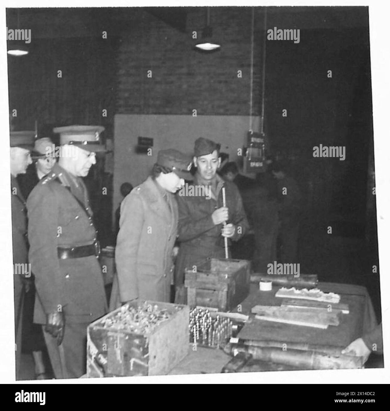 HRH THE PRINCESS ROYAL VISITS ORDNANCE DEPOT - HRH visited a section of the Depot which deals with 6-pdr. anti-tank shells. Here a senior officer is explaining pointsof interest to HRH British Army Stock Photo