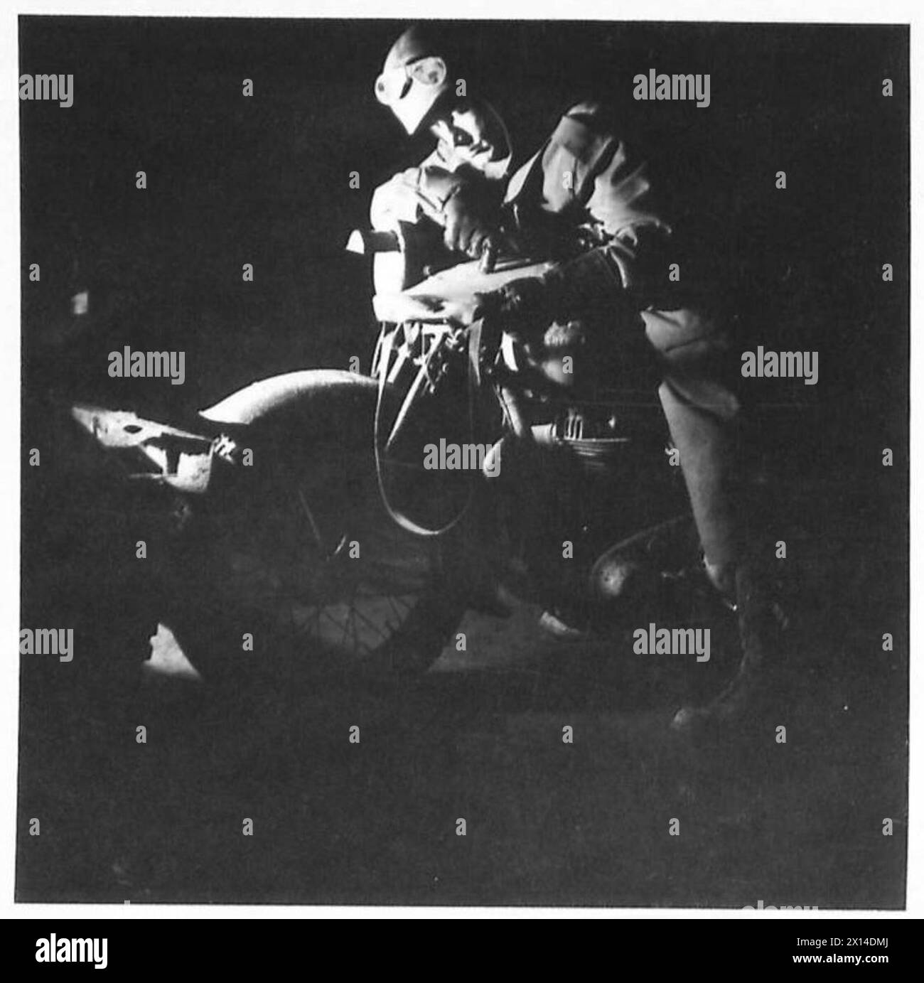A British dispatch rider navigates in Holland at night, reading his map ...