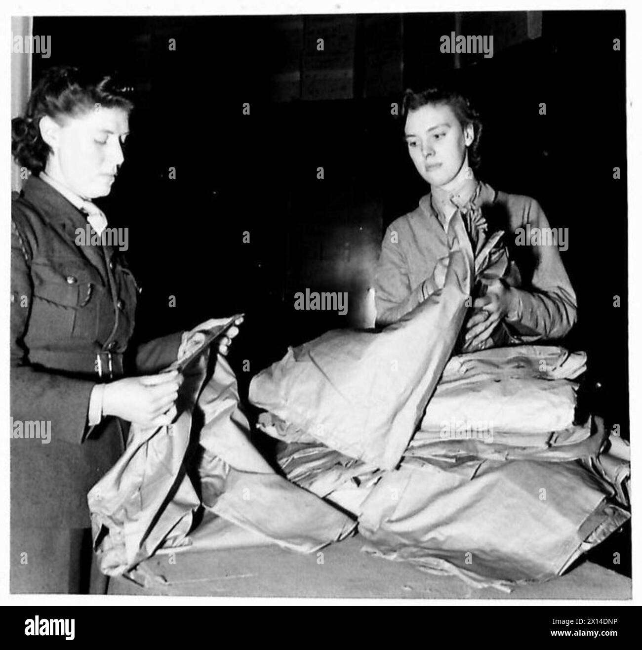 ATS AT WORK IN ORDNANCE DEPOT - L/Cpl Gladys Gardner and her sister Pte. Margaret Gardner of Stoke,on Trent are serving together at an Ordnance Depot in the Midlands. Gladys, who is 23 worked in a tile factory before the War. She was one of the first volunteers for the Service in 1938 and was called up two days after War broke out. Margaret 20, who formerly worked with her sister and later went into munitions, joined up as year ago. Now they are both working as storewomen, handling vast stocks of ATS uniforms. They have two brothers in the Royal Artillery, one in the RAF and another in the ATC Stock Photo