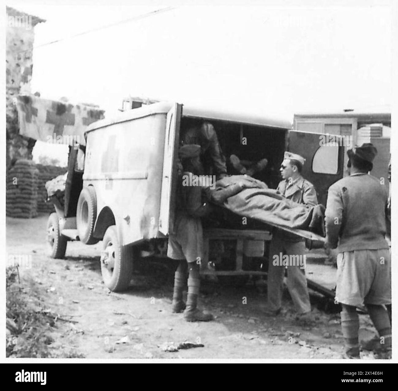 A wounded Indian soldier is transferred from an ambulance to a Regimental Aid Post during Eighth Army Allied operations against the Gustav Line in Italy under British Army supervision. Stock Photo