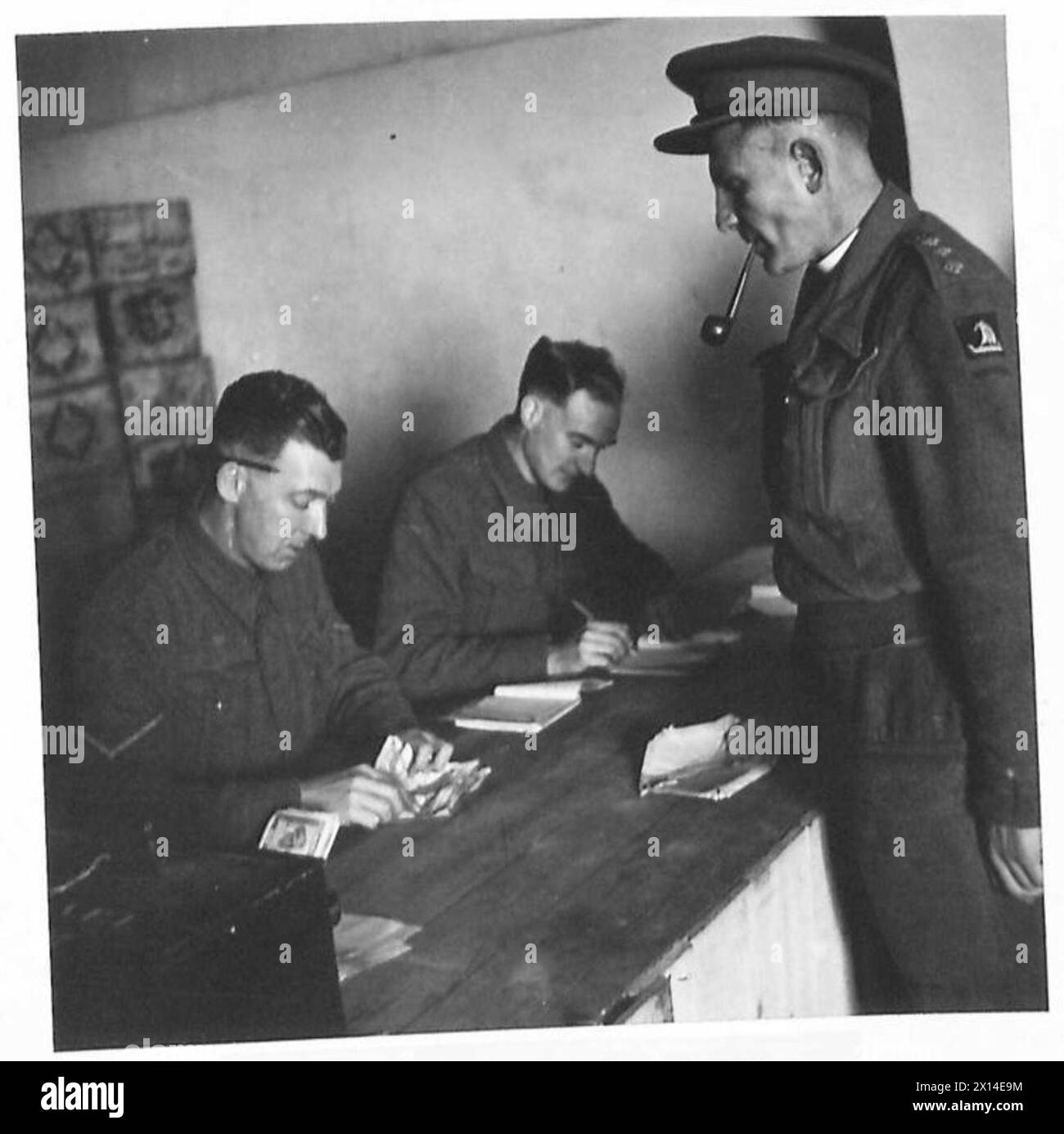 NAAFI SUPPLIES FOR FRONT LINE UNITS - Capt. Elworthy (Padre) paying for his unit order. The cashier is Cpl. Dunbar of Bargeddie, Scotland British Army Stock Photo