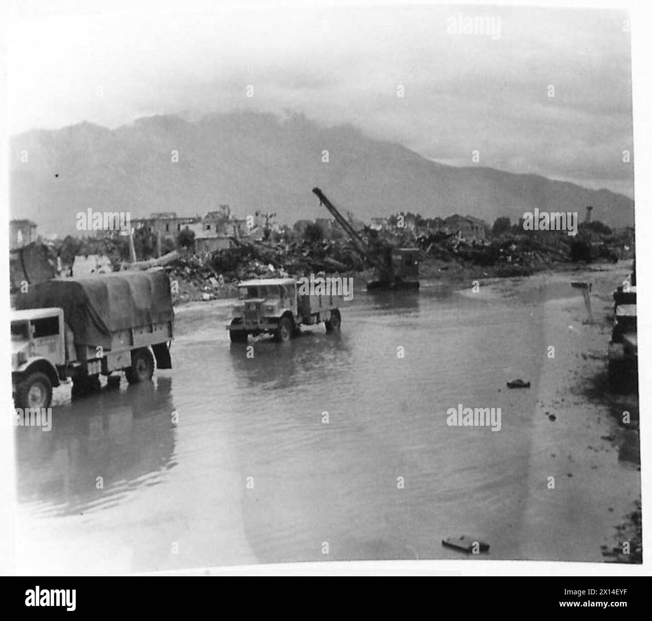 ITALY : EIGHTH ARMY : RAILWAY RECONSTRUCTION - Two days continuous rain added to the difficulties of the construction companies. Truck and a crane standing in a pool of water at Roccasecca station British Army Stock Photo