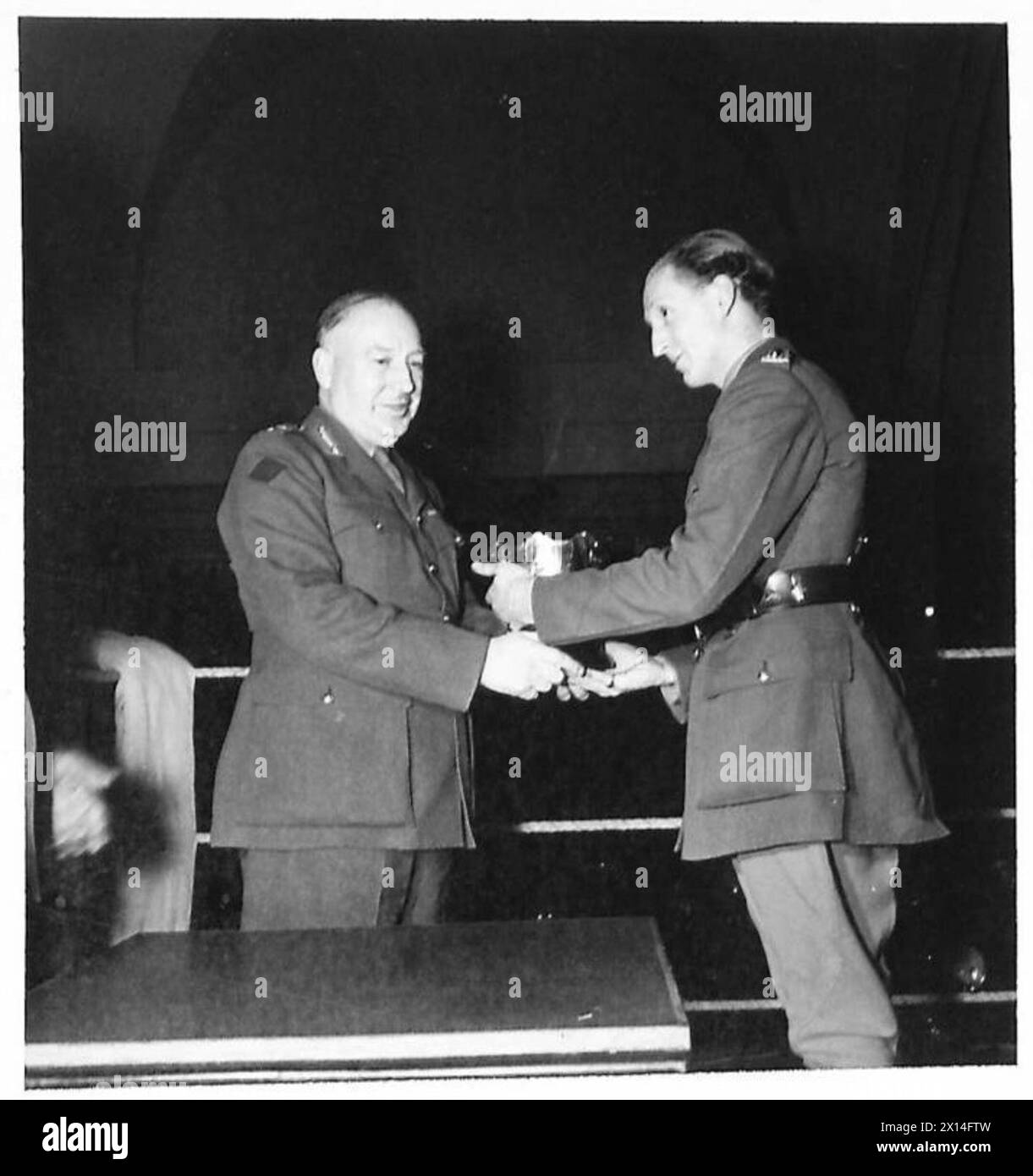 MILITARY BOXING TOURNAMENT - Prize giving in the ring after the boxing (left) Lt. Gen. E.W. Sanson, DSO, GOC of 2nd Canadian Corps presenting the Bowl to (right) Capt E.H. Leathers the Captain of the Canadian Army (Overseas) Team - the winners British Army Stock Photo