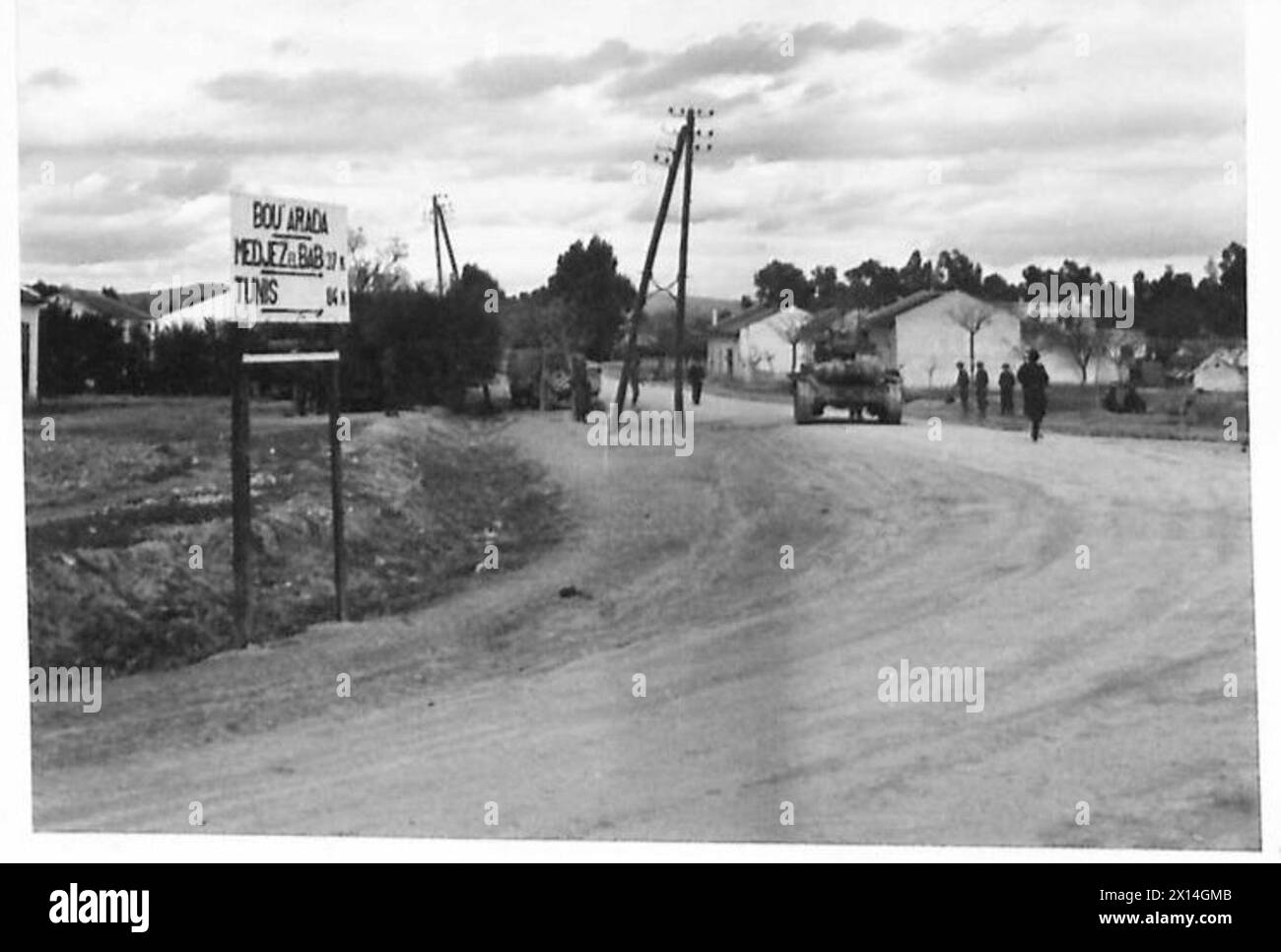 THE BRITISH ARMY IN THE TUNISIA CAMPAIGN, NOVEMBER 1942-MAY 1943 - A Valentine tank, probably of the 25th Army Tank Brigade, passing through Bou Arada on the Tunis road. The battle at Bou Arada flared up again. The Germans attacked from the 'Two Tree Hill' with tanks and infantry. Troops of the British V Corps in position on the 'Green Hill' (about 5000 yards away from the 'Two Tree Hill') held and beat back the attack. 17 German tanks were destroyed by British 25 pounder guns. The battle continued all day with Messerschmitts and Junkers dive bombing British positions. One ME and two JU 88s we Stock Photo