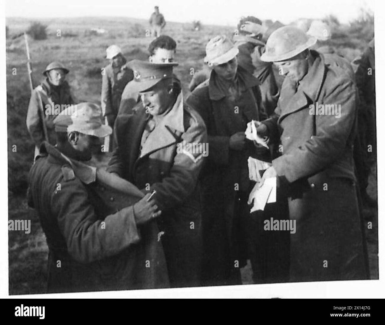 Eighth Army soldiers search German prisoners captured during the opening phases of the Mareth Line battle, totaling 1,700 taken. Stock Photo