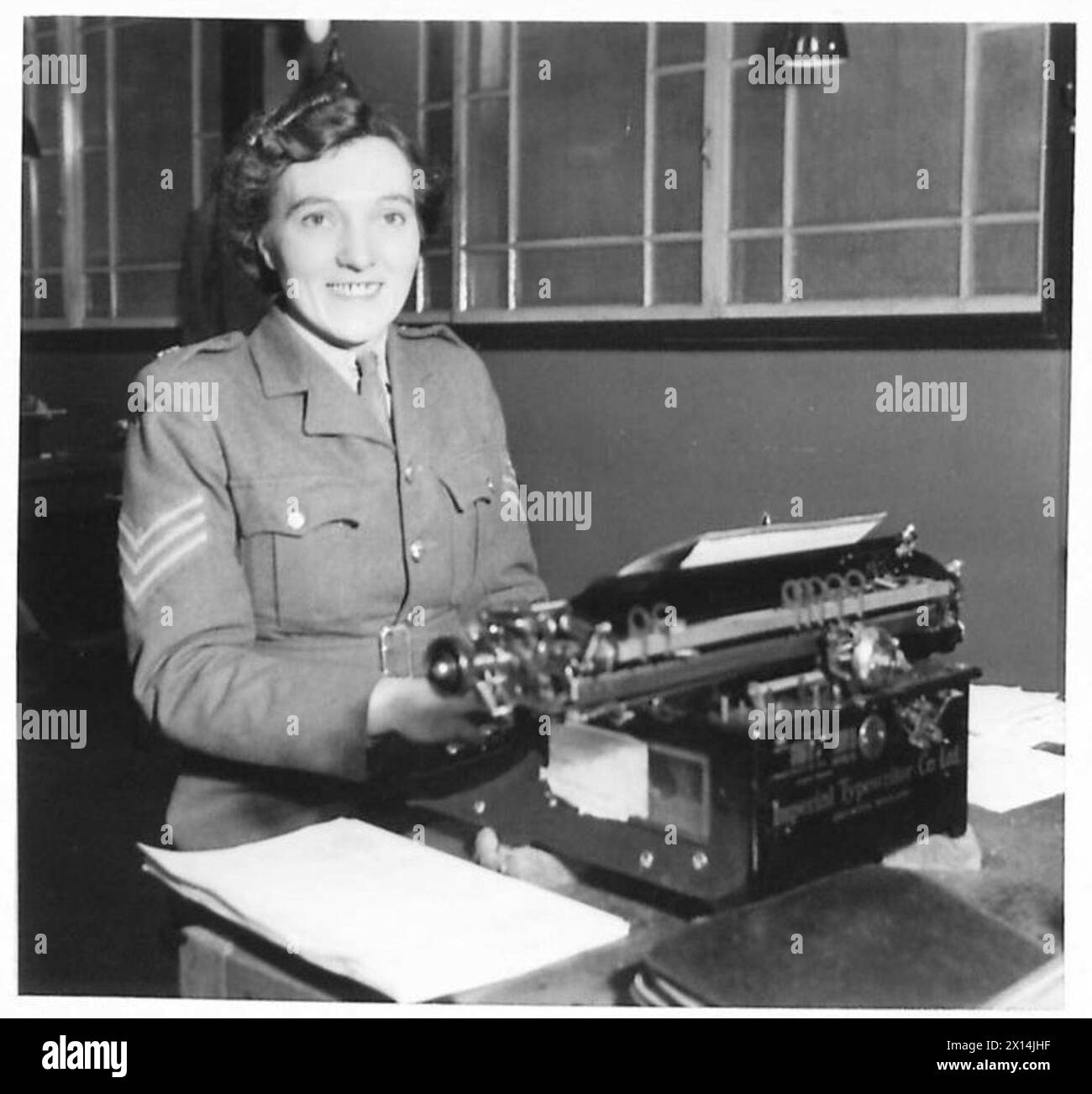ATS RECRUITING PHOTOGRAPHS - Sgt. Margery Chadwin, aged 29, was a shorthand-typist at Langley Hill, Nottingham. She volunteered in February 1939 for the ATS and was sent to train with the Sherwood Foresters. She is now a typist in the Stores at Chilwell - takes a great interest in her work and going all out for promotion. She said "I would not be out of the ATS for anything, and have never regretted joining the Service". CHILWELL ORDNANCE DEPOT. Sgt.M. Chadwin typing out a list of stores British Army Stock Photo