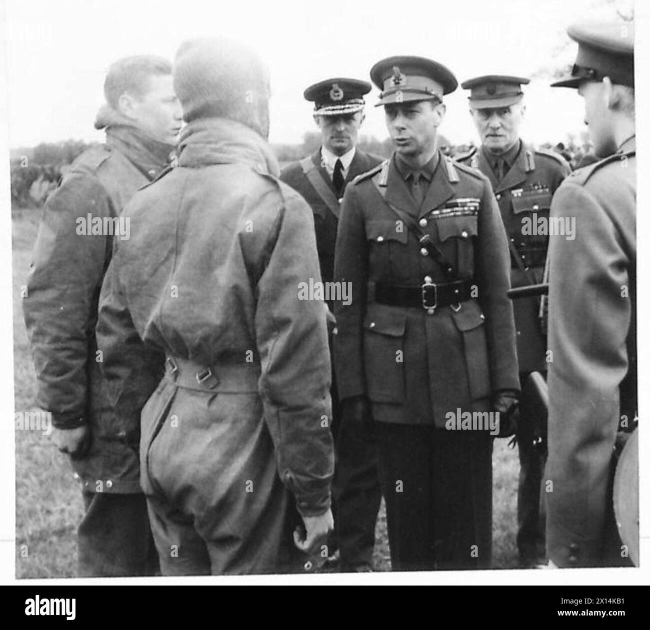 THE KING SEES PARACHUTE TROOPS IN ACTION - The King talking to paratroops after their drop British Army Stock Photo