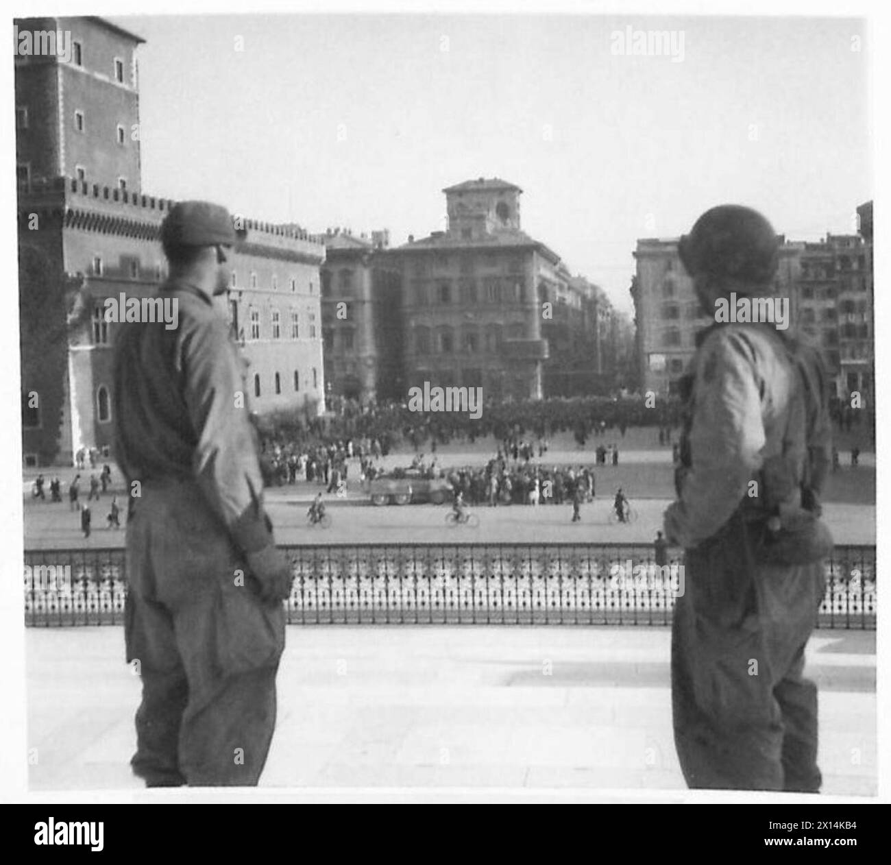 Two American soldiers observing the crowded Piazza Venezia as Rome ...