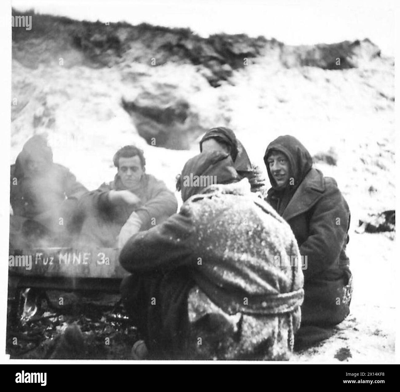 52 Div. WESTERN FRONT SNOW - It's all in a day's war work. Men of the 1st Batt. K.O.S.B. with snow andicicles, on their clothing, have a few minutes' respite from the trenches British Army, 21st Army Group Stock Photo