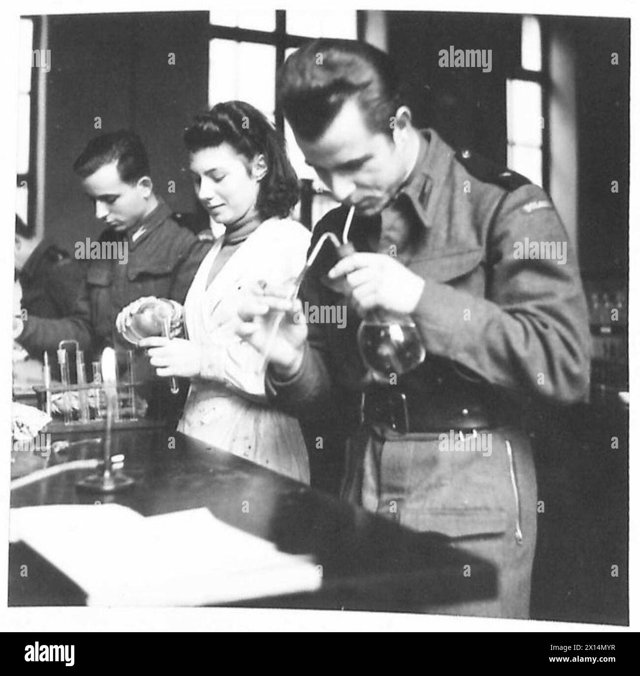 THE POLISH ARMY IN BRITAIN, 1940-1947 - Polish Army Second Lieutenants with female fellow student during a lesson in the chemistry laboratory. Professor Wright, the Dean of the Faculty at the University of St Andrews, offered General Marian Kukiel, the CO of the 1st Polish Corps, facilities for Polish Army students to continue their studies at the University. The offer was accepted and out of 350 candidates, 100 were selected for further education in English, political science, economics, French literature, arts, chemistry and research. Some of the students already hold degrees in Polish unive Stock Photo