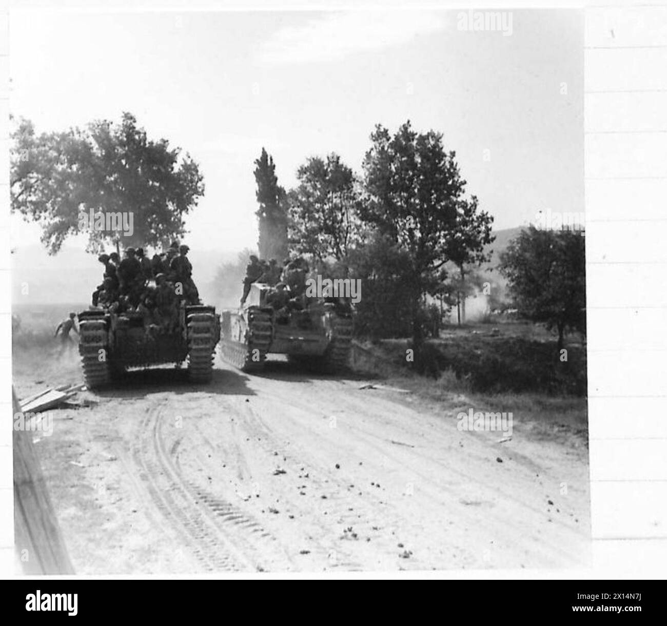 Churchill tanks carrying infantry advance along a road through the Gothic Line during Eighth Army operations in Italy. Stock Photo