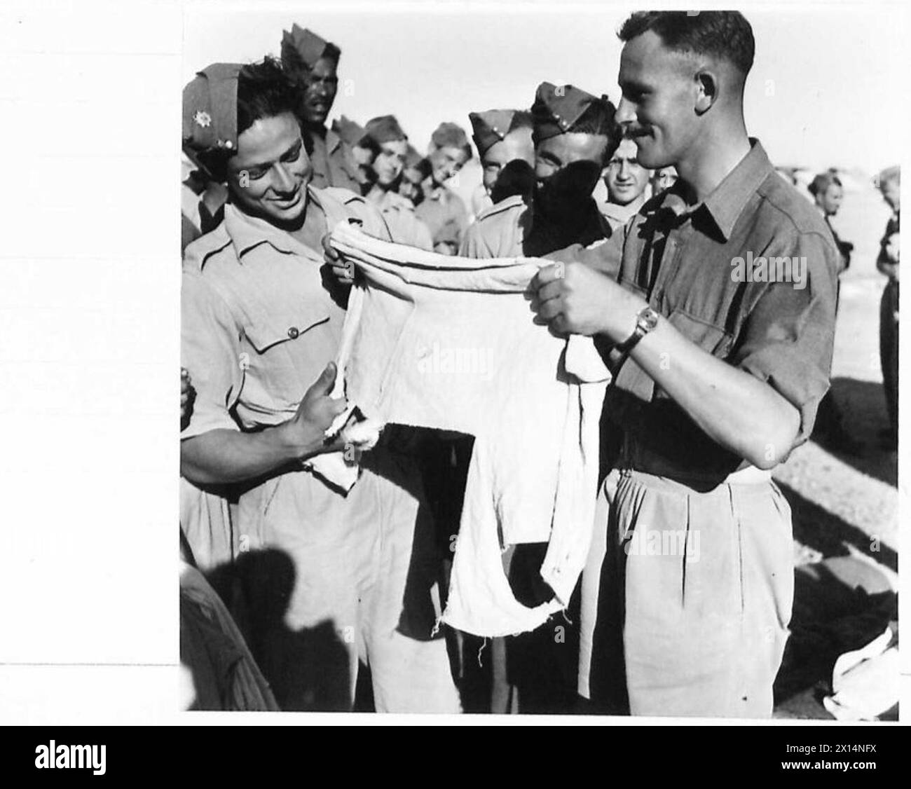 BRITISH EXPEDITIONARY FORCE TO FIGHT LOCUSTS IN THE MIDDLE EAST - Company orders stated that all clothing must be in good condition, so there was a great digging down into kitbags. Dvr. Magatey insists that the rag being held by CQMS Cuming of Hull was once a pair of pants United Nations Organisation [UNO] Stock Photo