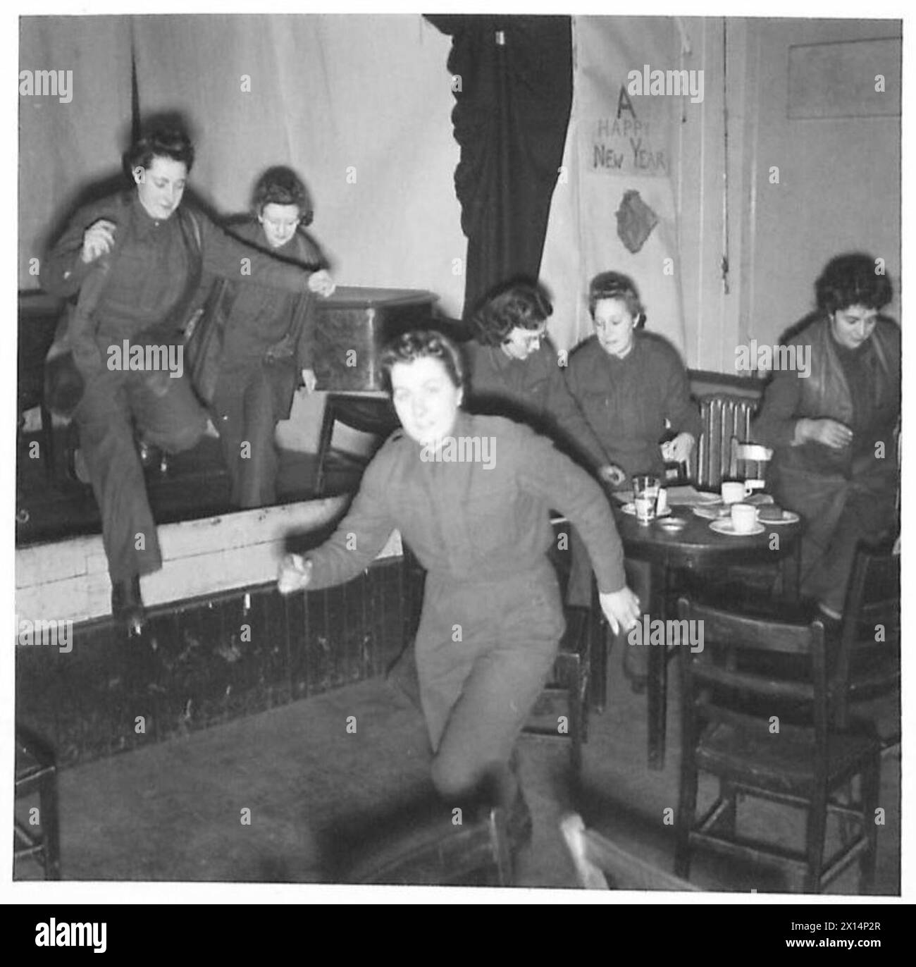 THE ACK-ACK GIRLS - The alarm goes 'Action Stations' - girls taking refreshment in the NAAFI sah to their actions stations on the gun site British Army Stock Photo