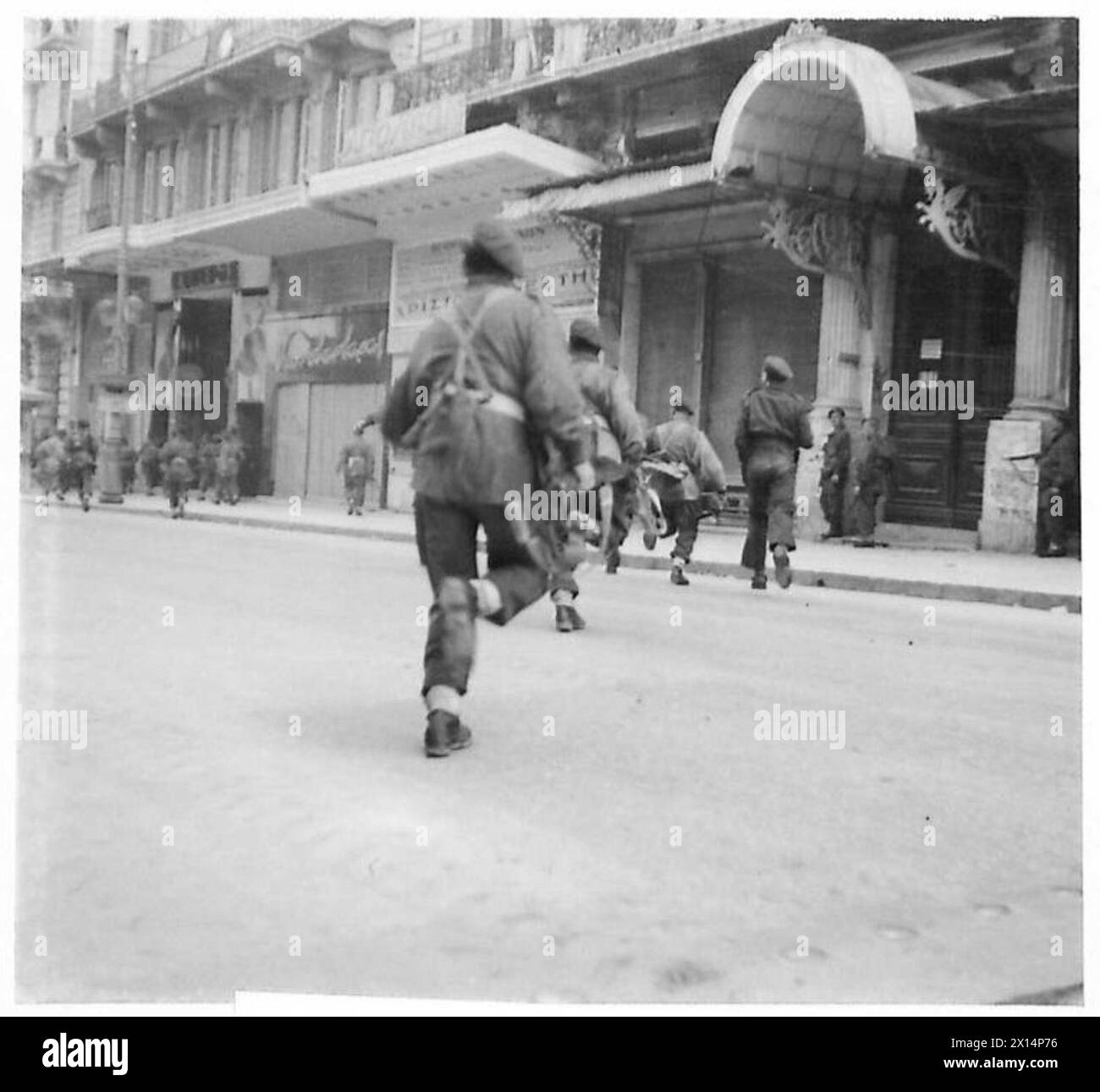 Paratroops move rapidly across a street under fire during civil war ...