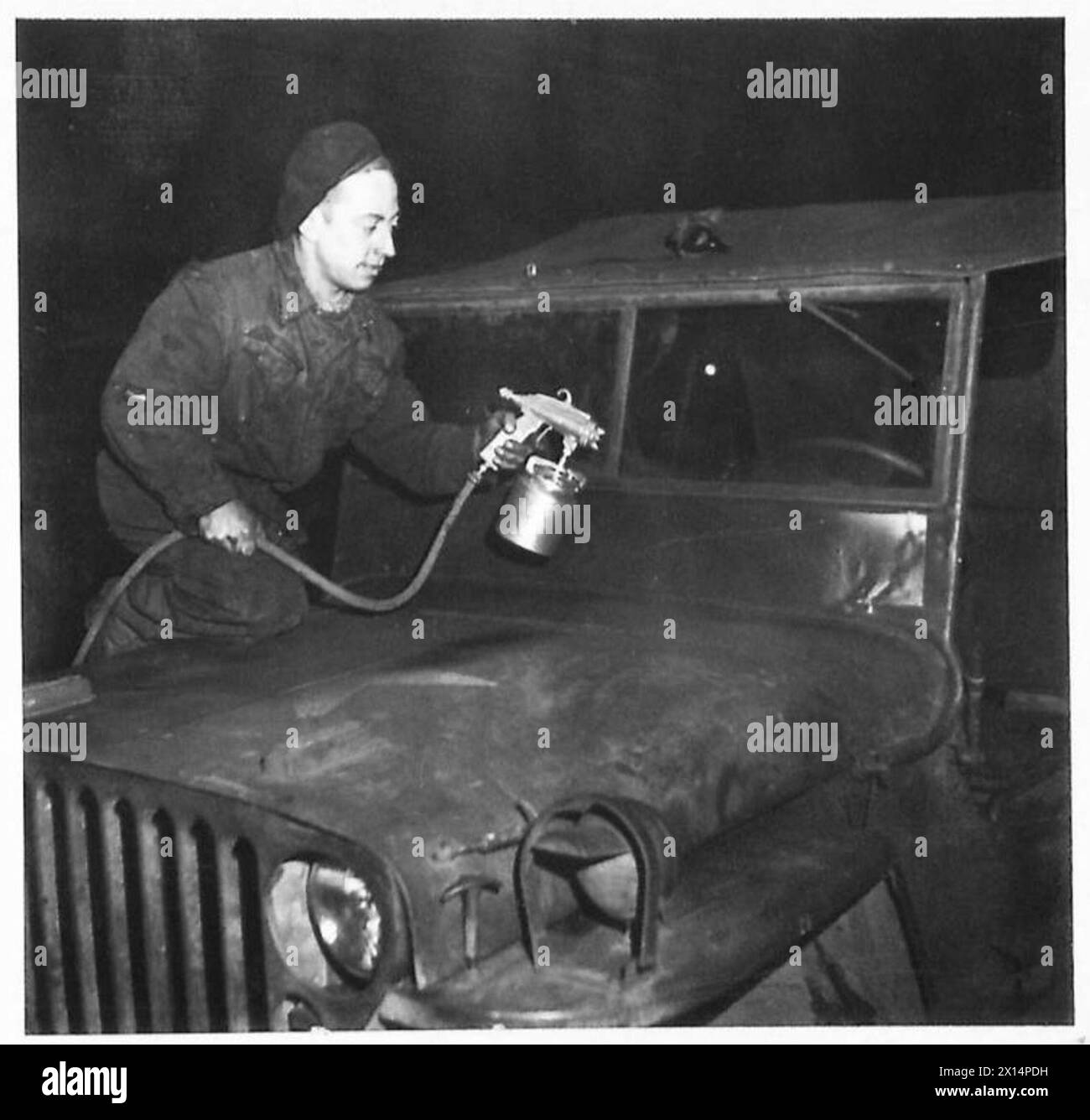 NEW JEEPS FROM OLD Pte S. Curtis, of Strood, Kent, paintspraying a