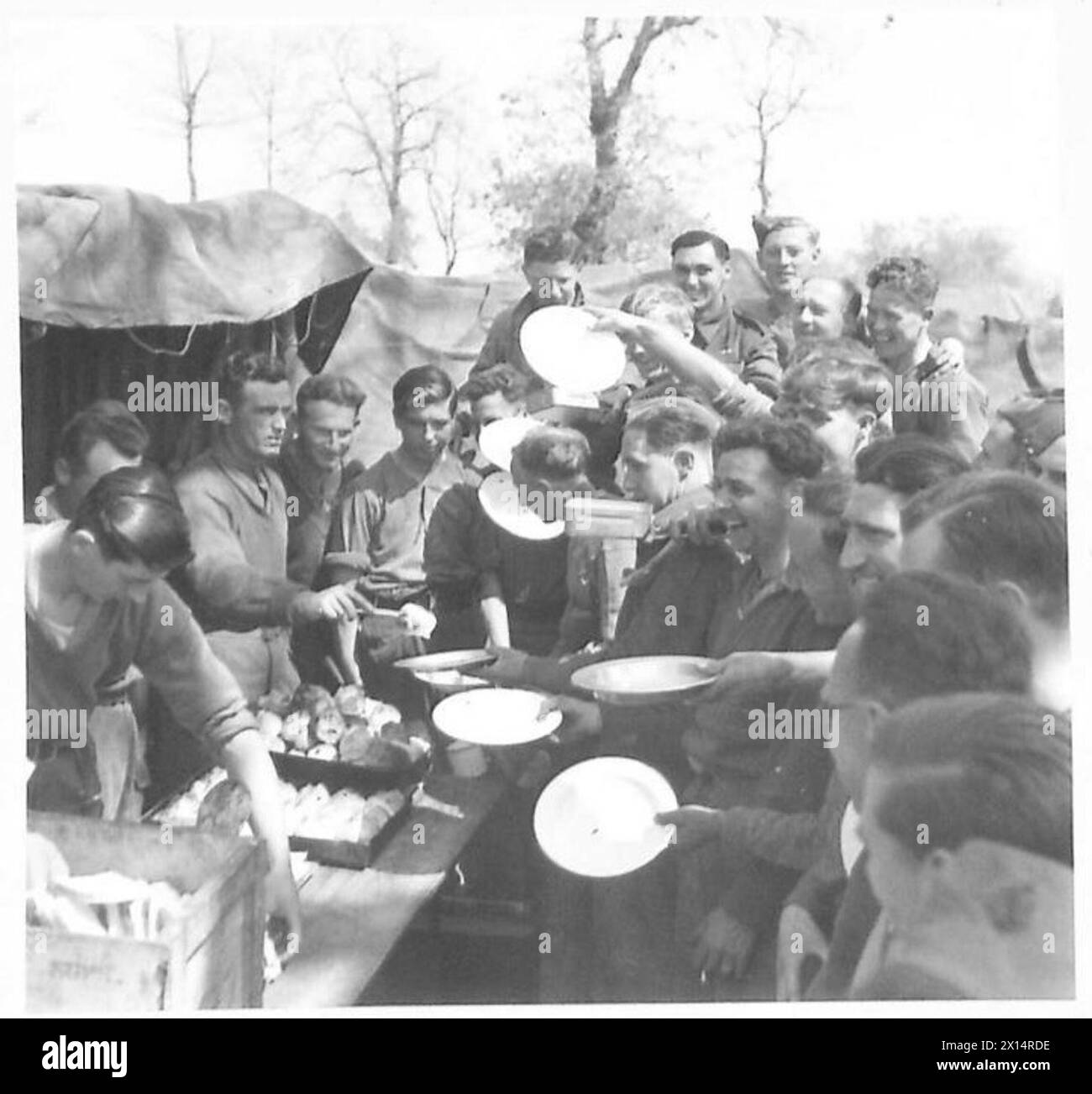 Troops of the Eighth Army line up to receive their issue of Hot Cross buns during a ration distribution. Stock Photo
