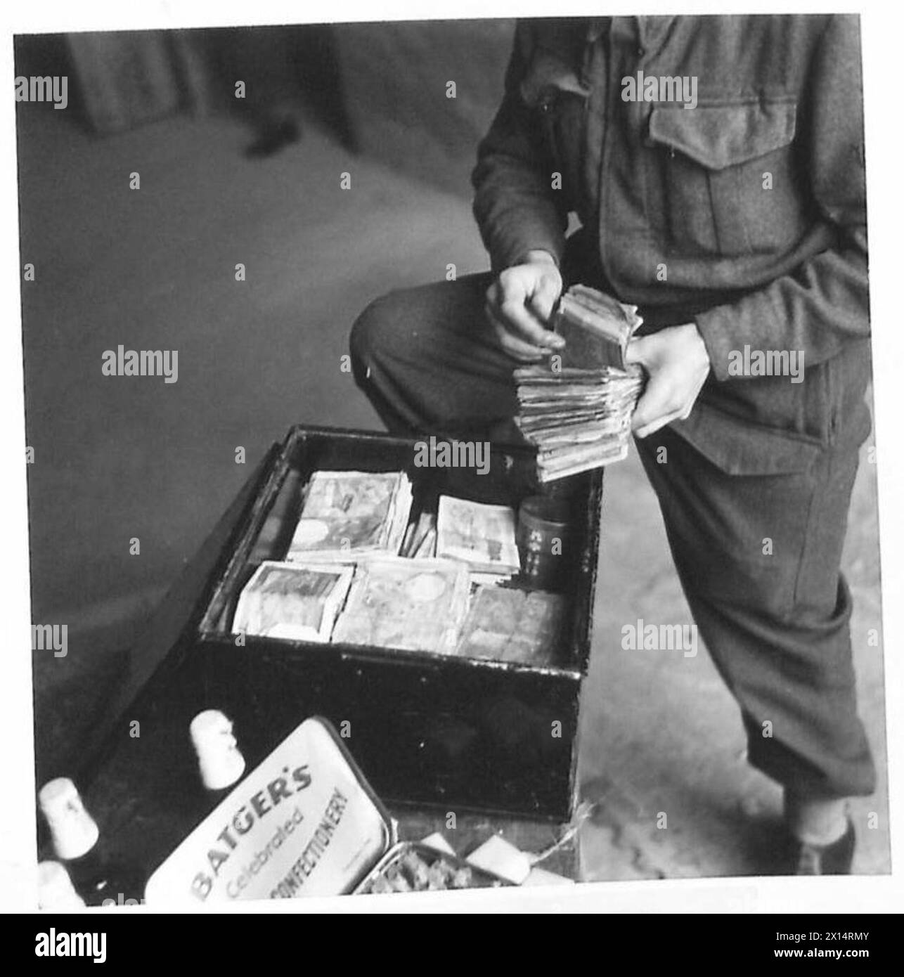 NAAFI SUPPLIES FOR FRONT LINE UNITS - What a sight for the Troops! The cashier counting some of the hundreds of French notes which change hands during the daily transactions British Army Stock Photo