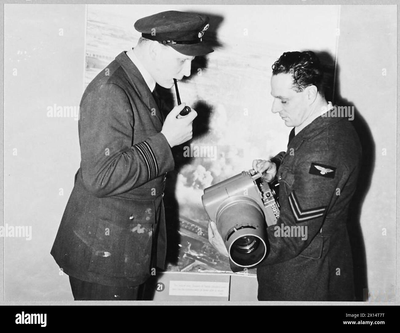 'CAMERA HAS WINGS' : R.A.F. EXHIBITION AT HARRODS - Picture taken at an exhibition of R.A.F.photographs on view at Harrods, Brompton Road, S.W.1. Picture (issued 1944) shows - Corporal A.C. Collingwood, an R.A.F. photographer, explaining modifications on an aerial camera to Squadron Leader R.A.B. Learoyd, VC Royal Air Force Stock Photo