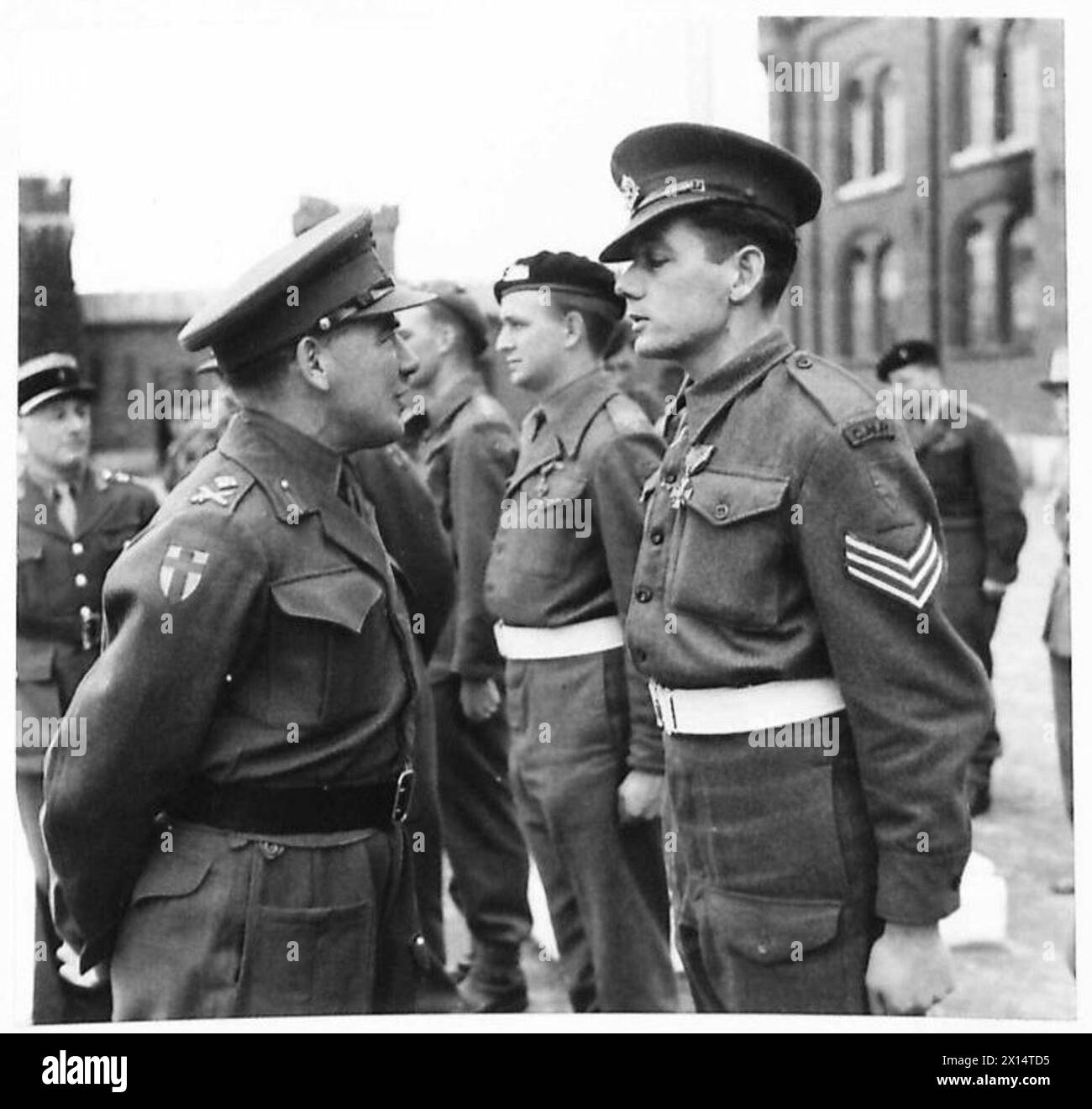 PRESENTATION OF CROIX PE GUERRE [613 REGT. R.A. , 37 R.H.U.] - General Surtees is seen chatting with Sergeant J.J. Lace of 244 Pro.Coy., after receiving the decoration British Army, 21st Army Group Stock Photo