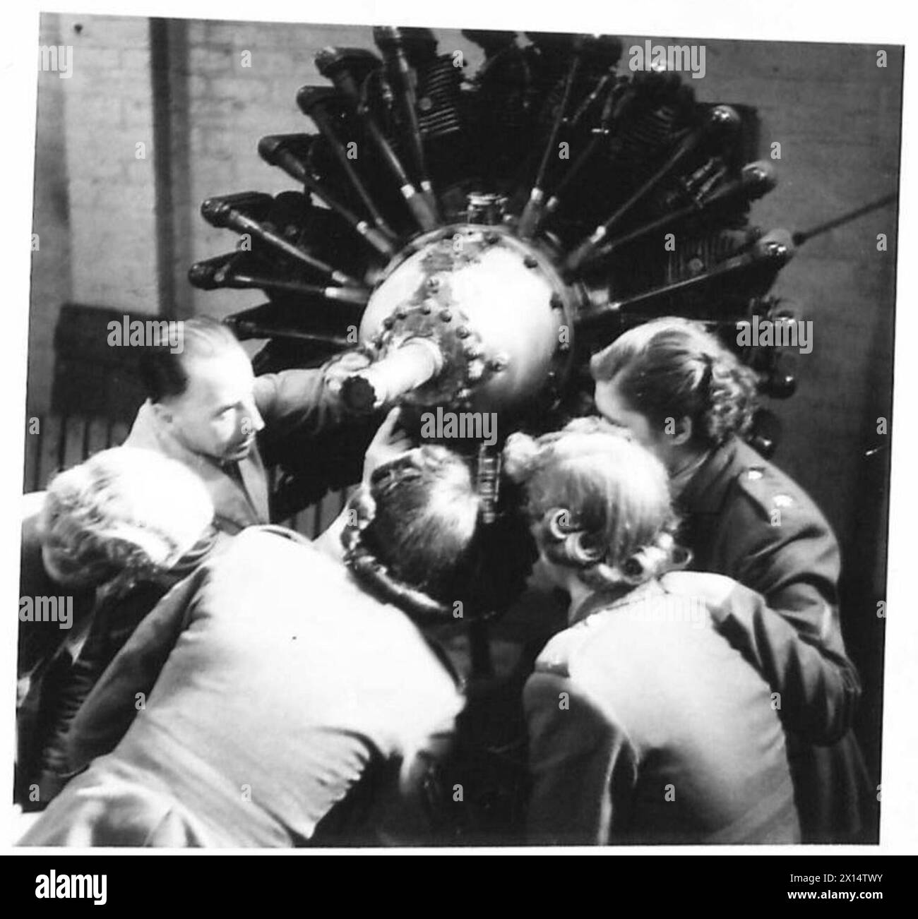 ATS members inspect an aeroplane engine during a handiwork course while ...