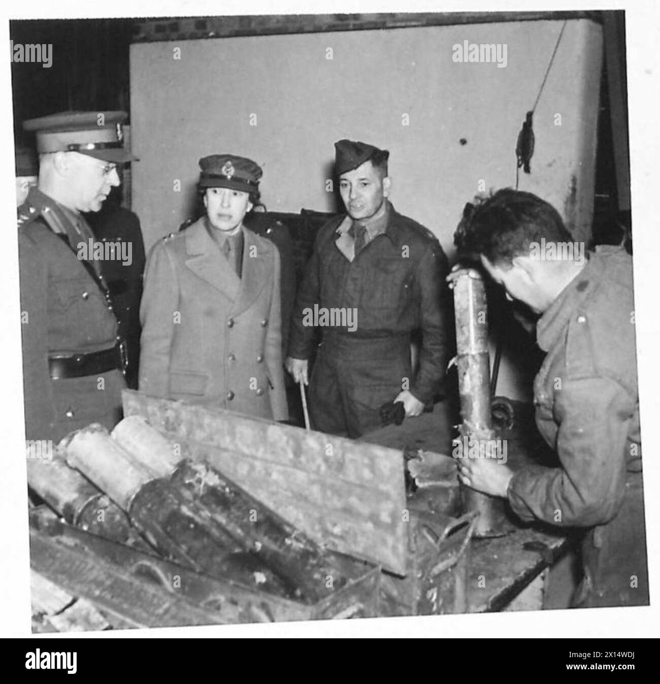 HRH THE PRINCESS ROYAL VISITS ORDNANCE DEPOT - HRH visited a section of the Depot which deals with 6-pdr. anti-tank shells. Here a senior officer is explaining pointsof interest to HRH British Army Stock Photo