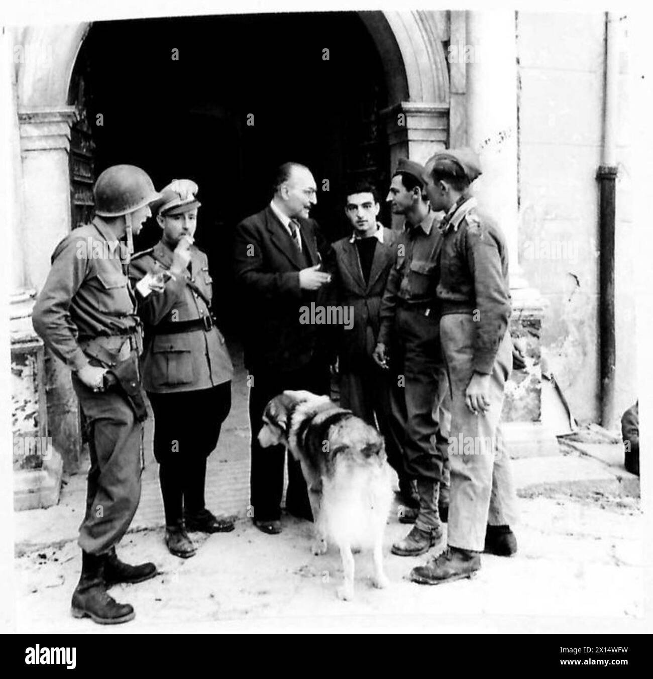 ITALY : FIFTH ARMY - British and American soldiers chat with the Mayor of Teano, Signor Marsegla Gaetano and an Italian policeman. They are Sgt. H. Paris of New York, the Italian policemen, Signor Marsegla Gaetano, a civilian, Sgt. Herman A. Marchi, of New York (representative of AMGOT) and Dvr.A.Bowers of Huddersfield British Army Stock Photo