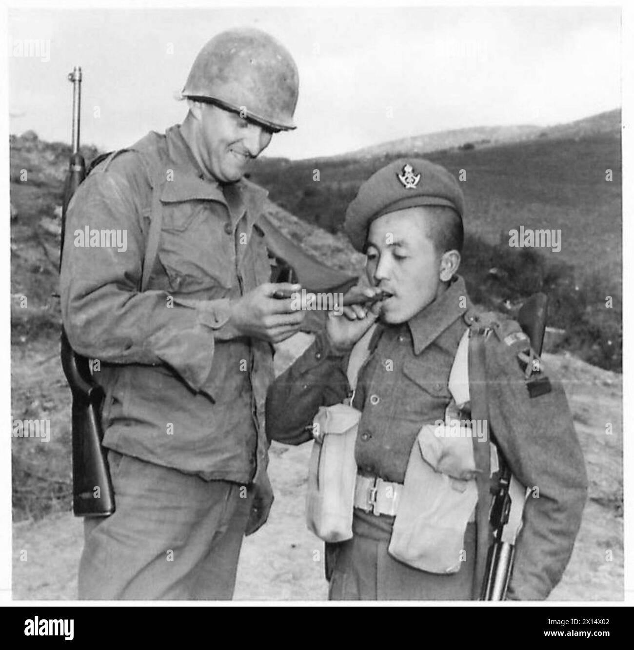 THE BRITISH ARMY IN NORTH AFRICA, SICILY, ITALY, THE BALKANS AND AUSTRIA 1942-1946 - Rfn. Limbu tries a cigar offered by his friend, Pfc. Trattles British Army Stock Photo