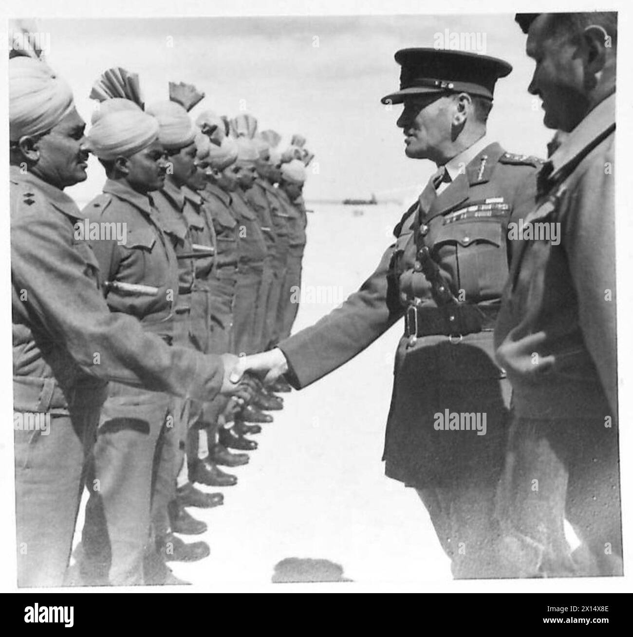 C-IN-C's TOUR OF 10TH ARMY - Lieut. Colonel C.E. Morris, DSO., introduces VCOs of the 4/13 Frontier Force Rifles to General Sir Claude Auchinleck. The C-in-C is shown shaking hands with Subedar Ghani Khan. 25 Brigade 10th Indian Division,Habbaniya Lake near Baghdad British Army Stock Photo