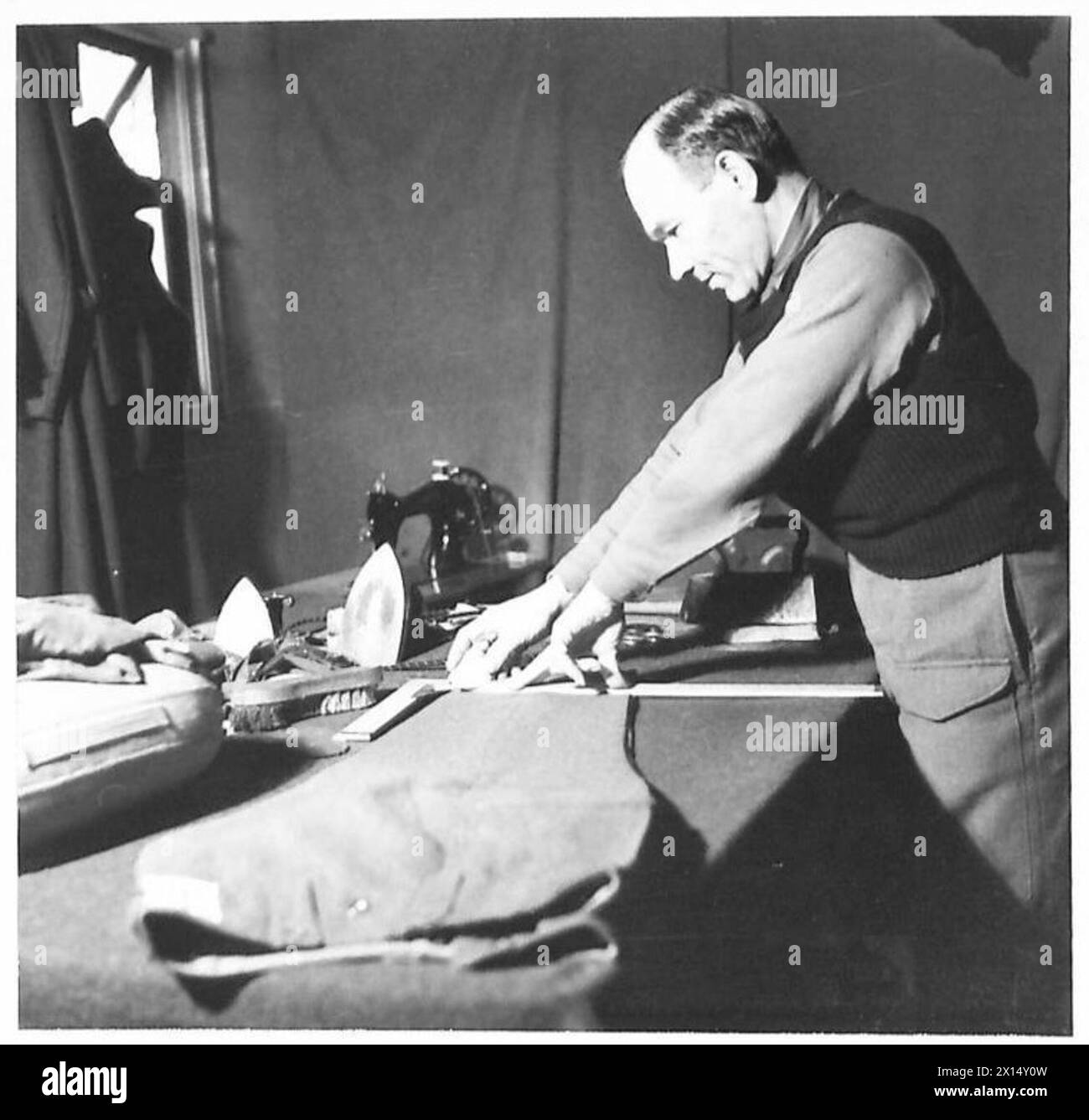 THE POLISH ARMY IN BRITAIN, 1940-1947 - Tailor of one of the Brigade units repairing and altering uniforms for the officers and men. Photograph taken at Perth. A special series of photographs dealing with the domestic and social life of troops of the 1st Polish Rifle Brigade (1st Polish Corps) in Scotland where the officers and men are firmly established favourites with the local people. Some of the young soldiers were attending universities in Poland when war broke out. On arrival in Britain they joined the Polish Forces and continued their studies at the St Andrews University in order to fin Stock Photo