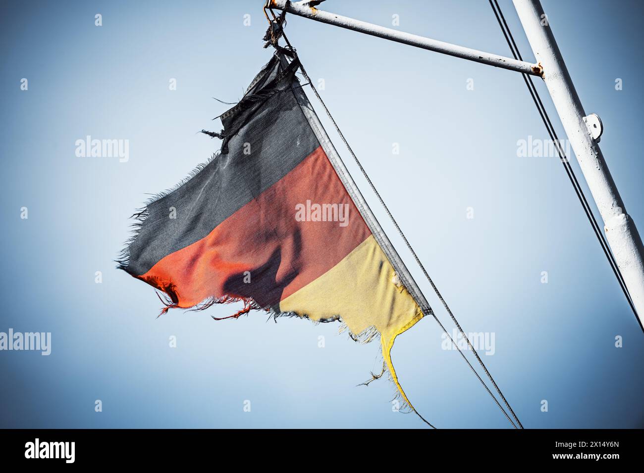 Tattered German Flag In The Wind, Crisis, Inflation, Recession Stock Photo