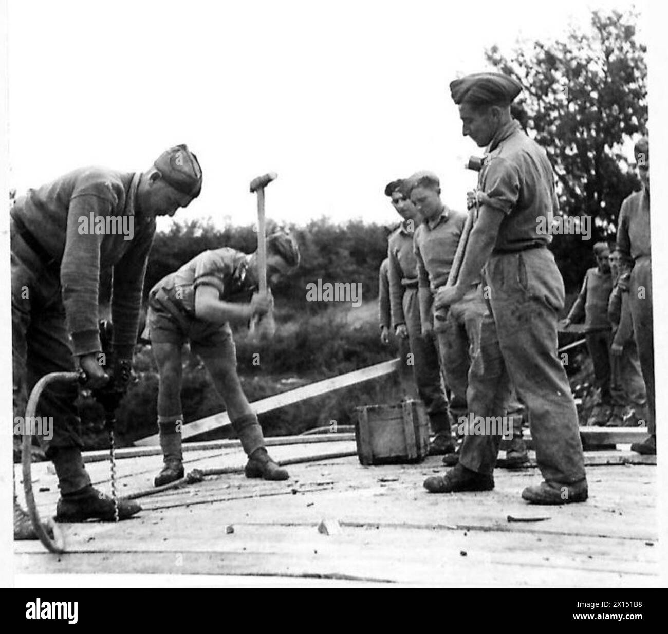 ITALY : EIGHTH ARMY BRIDGE MAKING - Hammering in the spikes which hold the massive timbers together , British Army Stock Photo