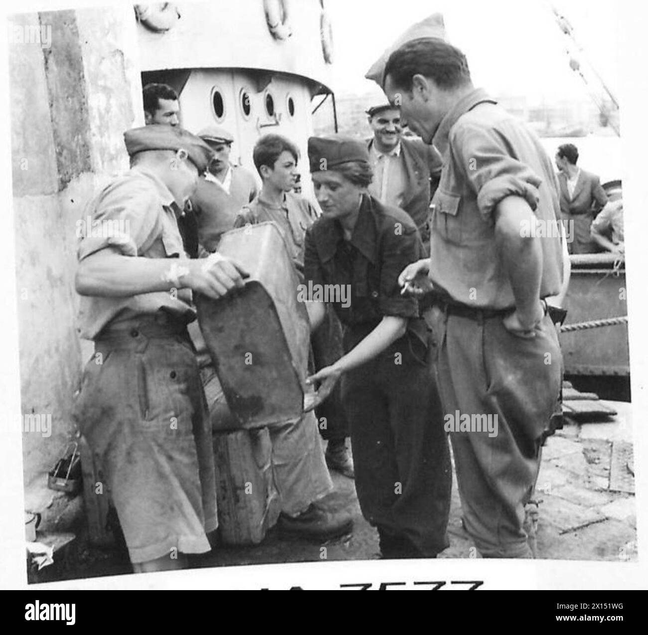 YUGOSLAVS IN ITALY - One of the Jugoslav fighting patriots, Zina Nadan Zon, is here seen on the quayside,receiving water from one of the English soldiers of a nearby A.A. gun British Army Stock Photo