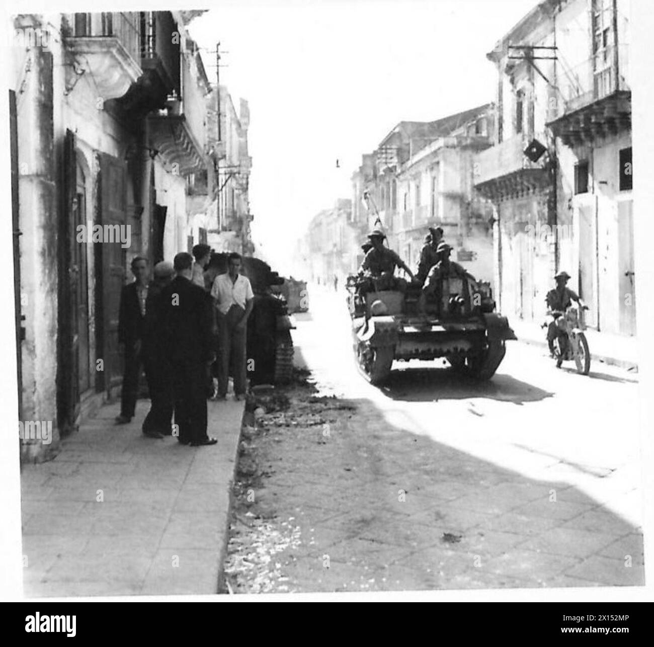 INVASION OF SICILY - British Bren carrier passing the burnt out French tank in Floridia British Army Stock Photo